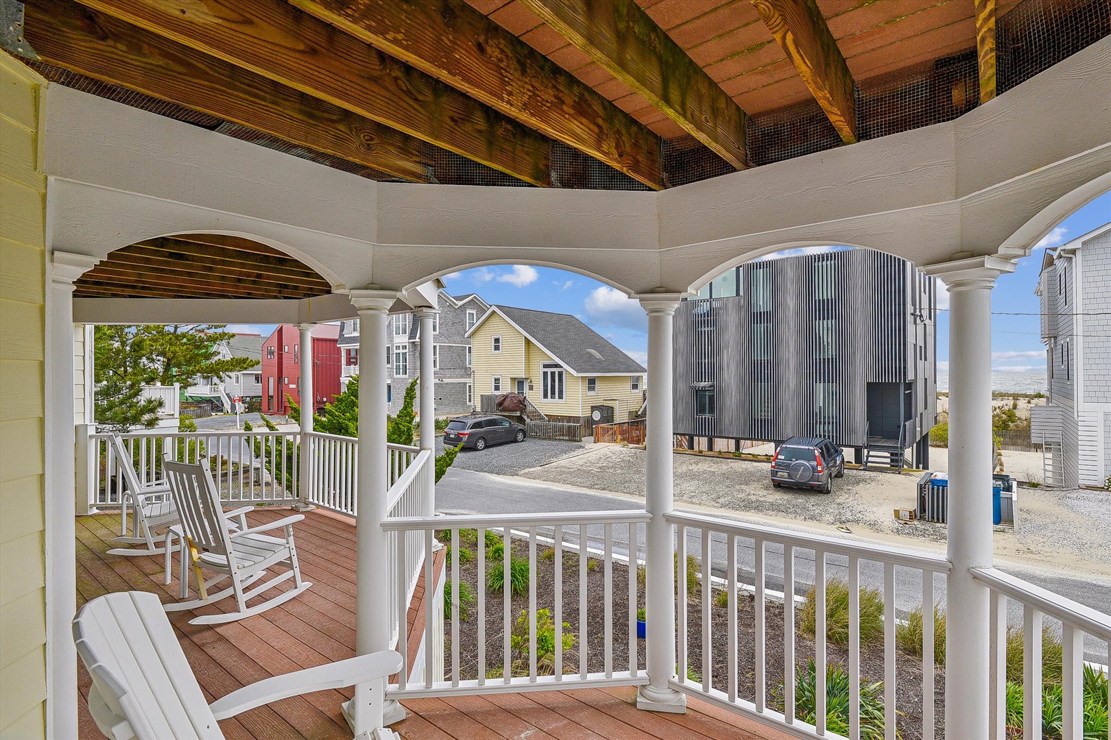 Charming wraparound porch with classic columns and rocking chairs—your perfect spot to sip morning coffee and watch the neighborhood come alive.