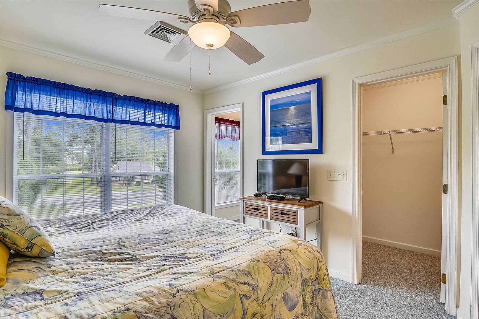 Sink into a cozy bed with a ceiling fan overhead and unwind while watching your favorite shows. Your private closet and bright windows create a peaceful retreat for relaxing after a day of adventure.
