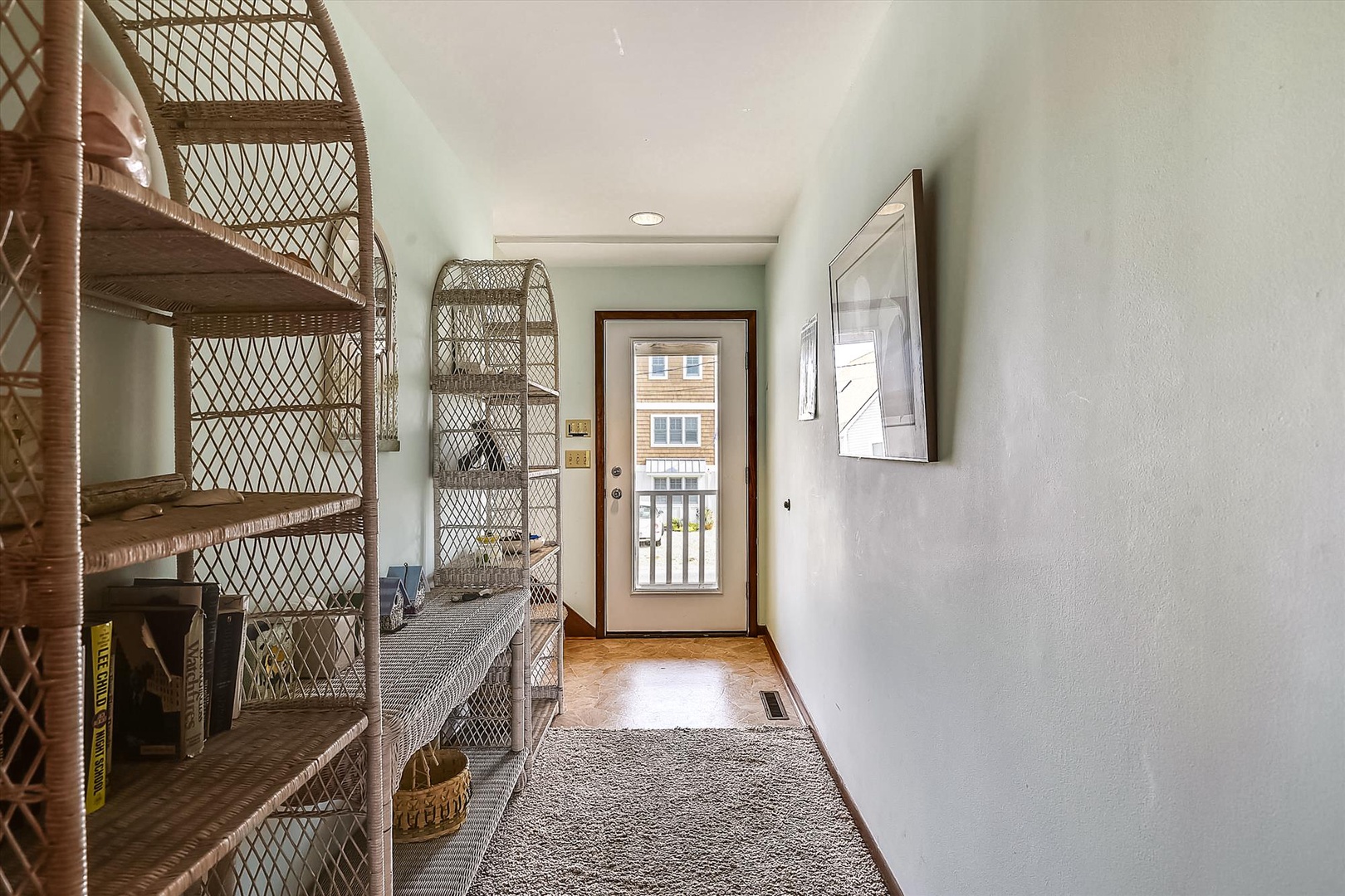 A bright entryway welcomes you with woven coastal details and wood floors—your peaceful retreat starts the moment you arrive.