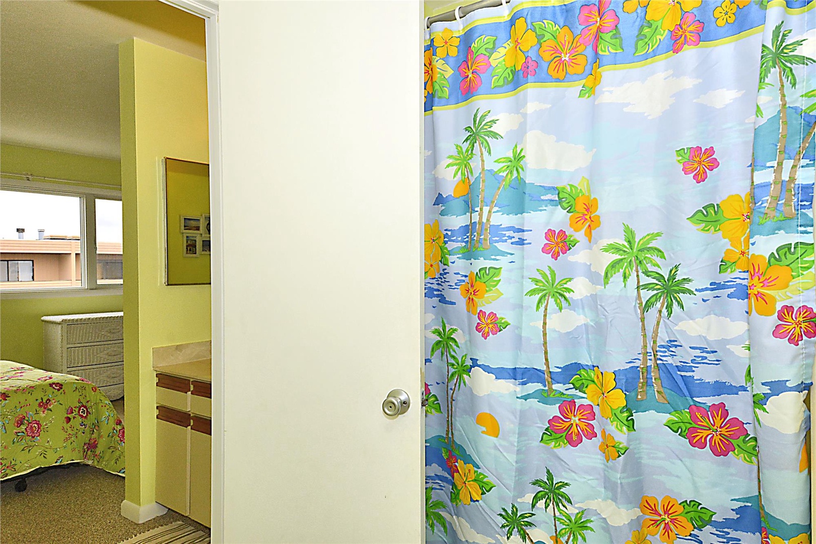 You'll appreciate the home's cheerful tropical decor and convenient layout connecting your cozy bedroom to the private bathroom adorned with vibrant island-themed touches.