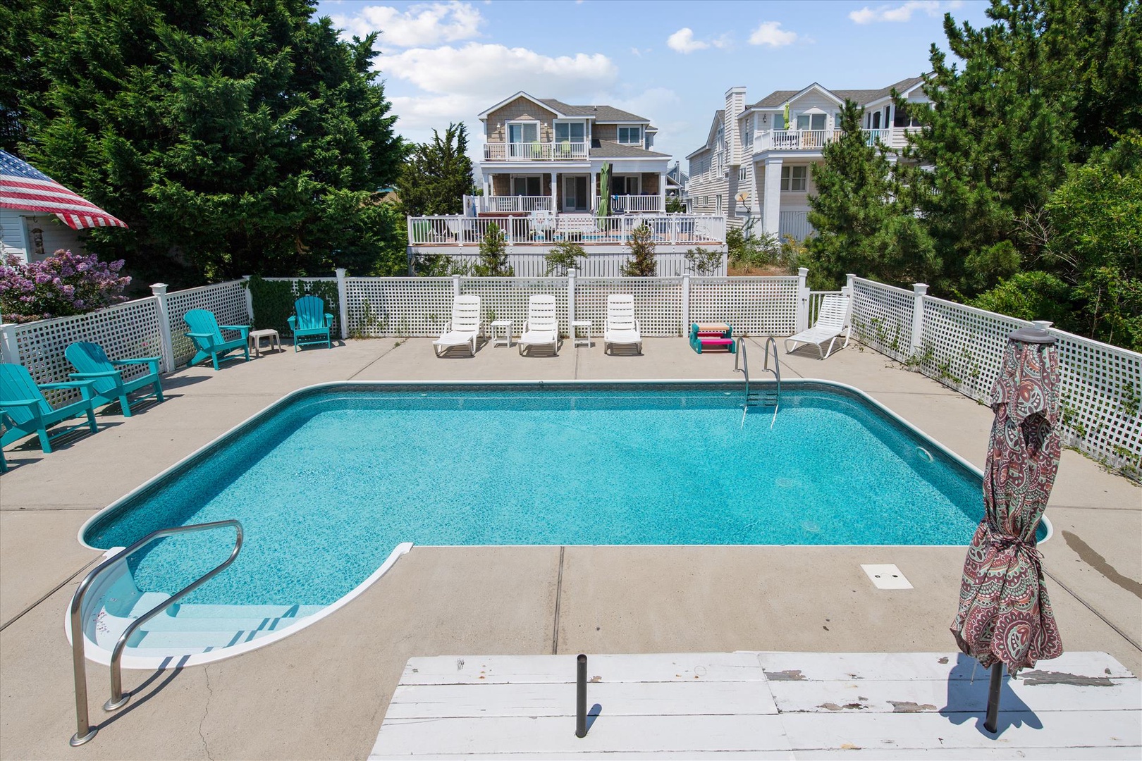 Dive into your own sparkling oasis, surrounded by comfortable lounge chairs and privacy fencing, with stately vacation homes framing the backdrop for endless sunny days.
