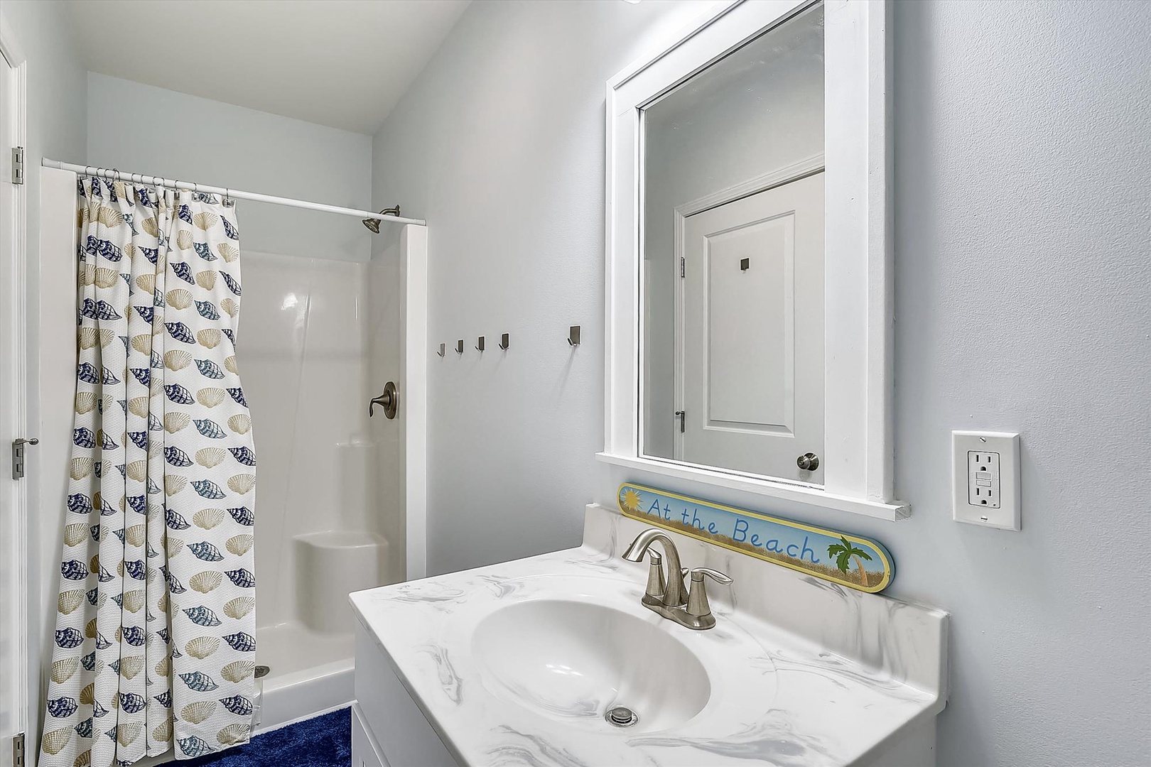 Freshen up in your bright, spotless bathroom with coastal touches that echo the beach vibes just beyond your door.