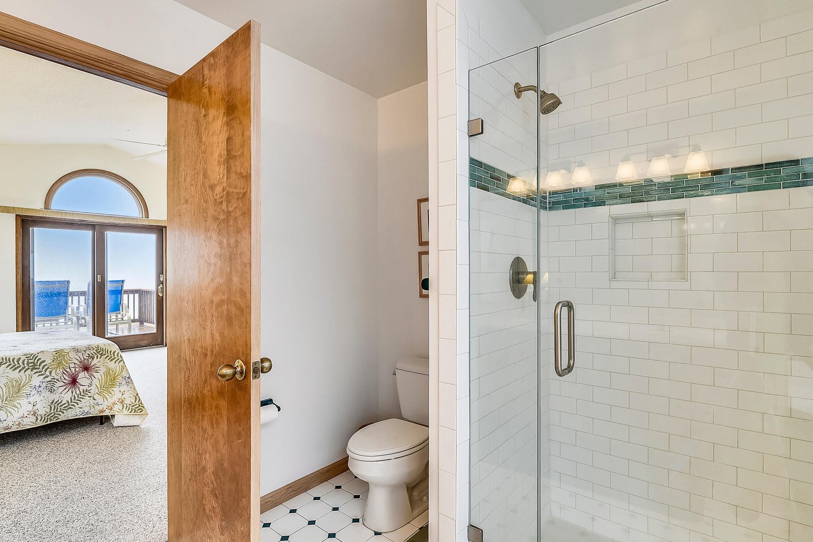 Refresh in your bright ensuite with a glass-enclosed shower and crisp subway tile, then step through that open door to a stunning ocean view waiting just beyond your bedroom.