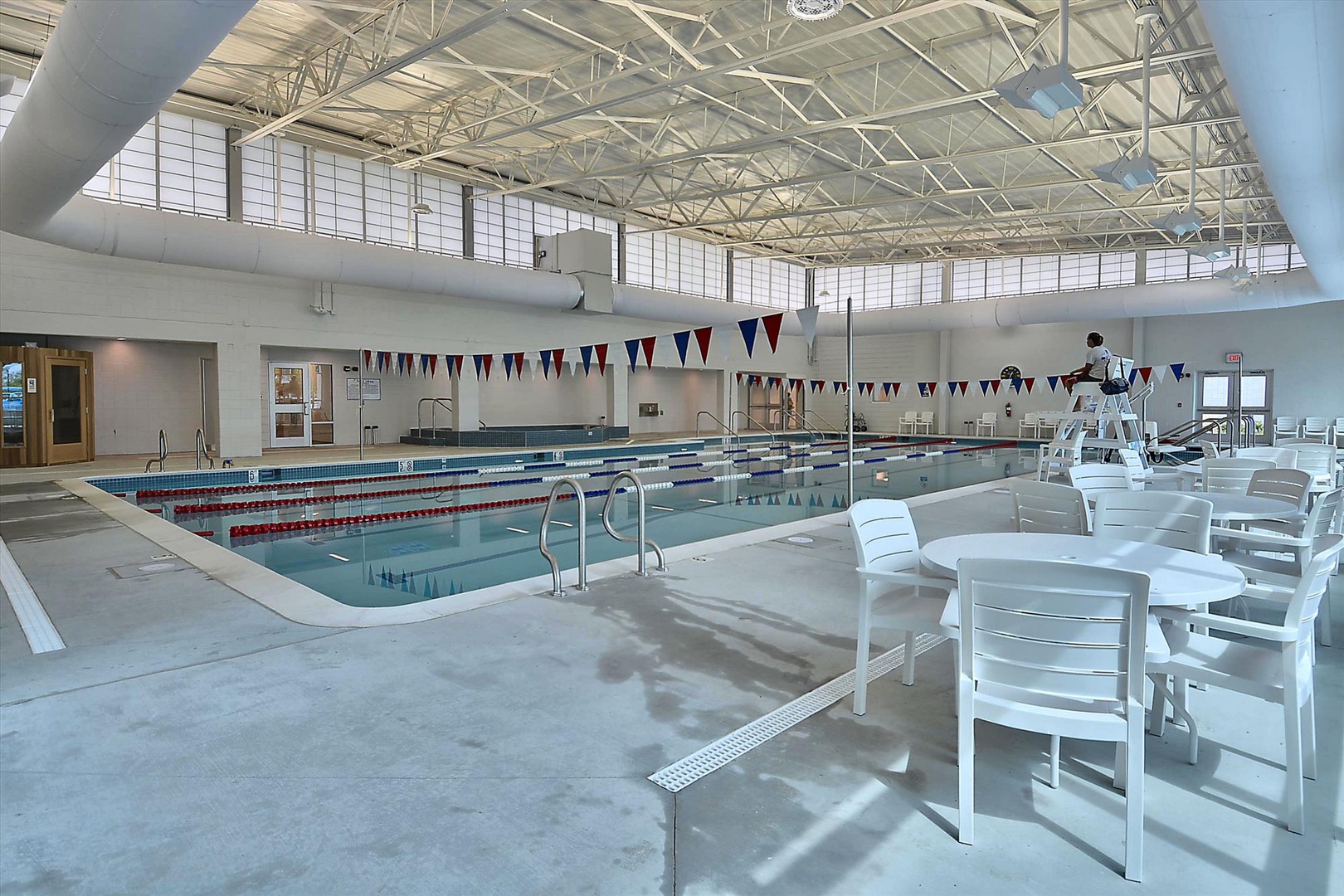 Dive into your morning laps in the pristine indoor pool, then relax poolside at crisp white tables—your refreshing workout awaits under soaring sunlit ceilings.