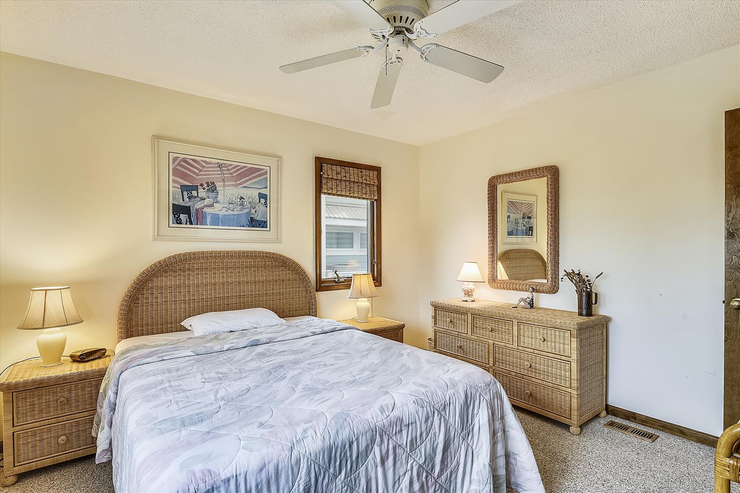 Drift off in your peaceful bedroom with natural wicker furniture, soft lighting, and a ceiling fan to keep you comfortable all night.