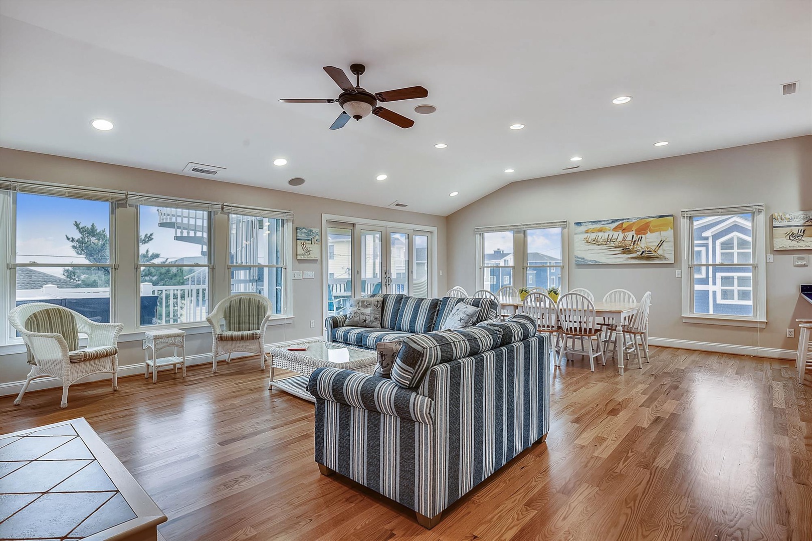Gather with loved ones in this spacious, light-filled great room where coastal breezes meet comfort. Relax in the open living and dining area with gleaming hardwood floors and panoramic windows.