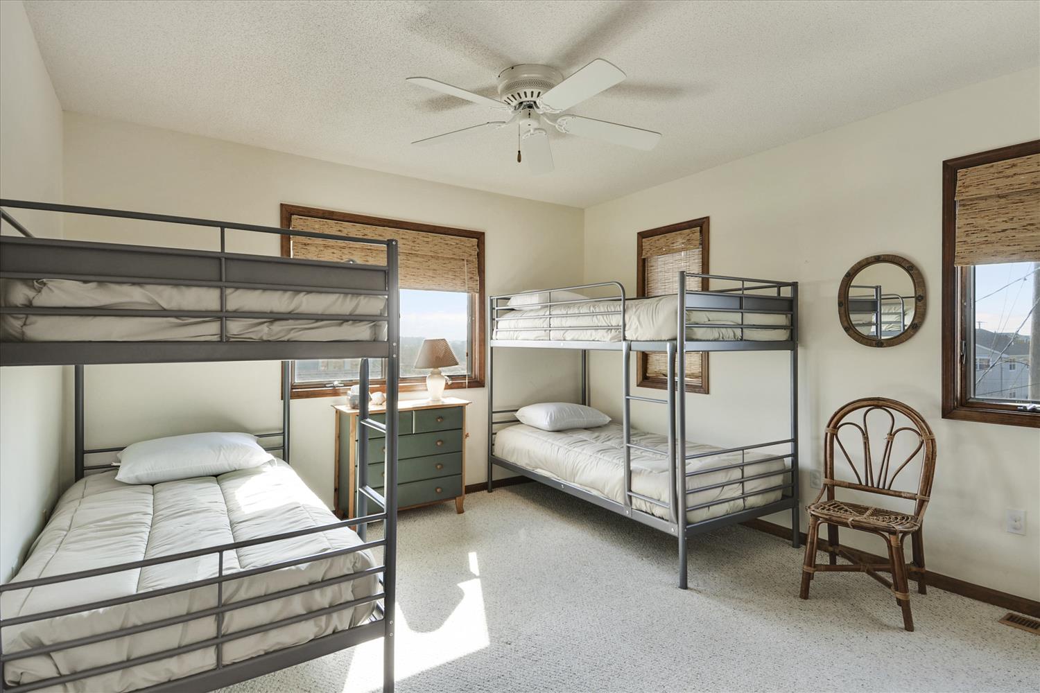 Cozy bunk room with room for the whole crew. Natural light filters through bamboo shades, and a ceiling fan keeps your space comfortable year-round.
