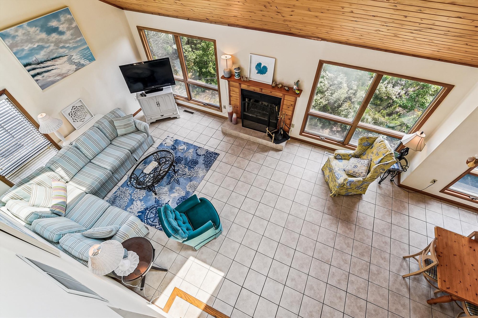 Relax in your spacious living room with soaring ceilings, abundant natural light, and cozy fireplace. The open layout invites you to unwind on plush seating while enjoying forest views through expansive windows.