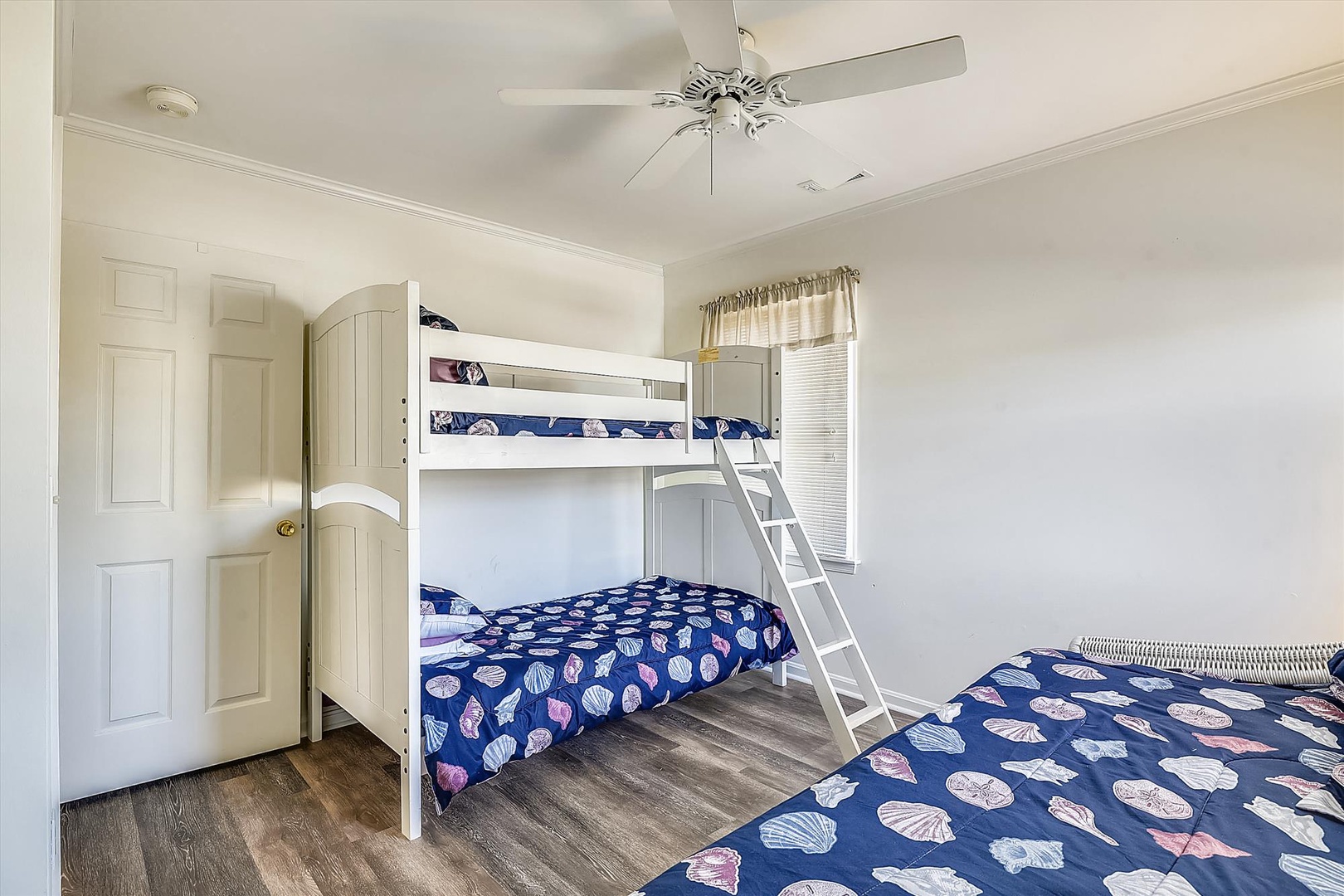 Your family can spread out comfortably in this bright, airy bedroom featuring a charming bunk bed and extra sleeping space—perfect for kids or groups traveling together.