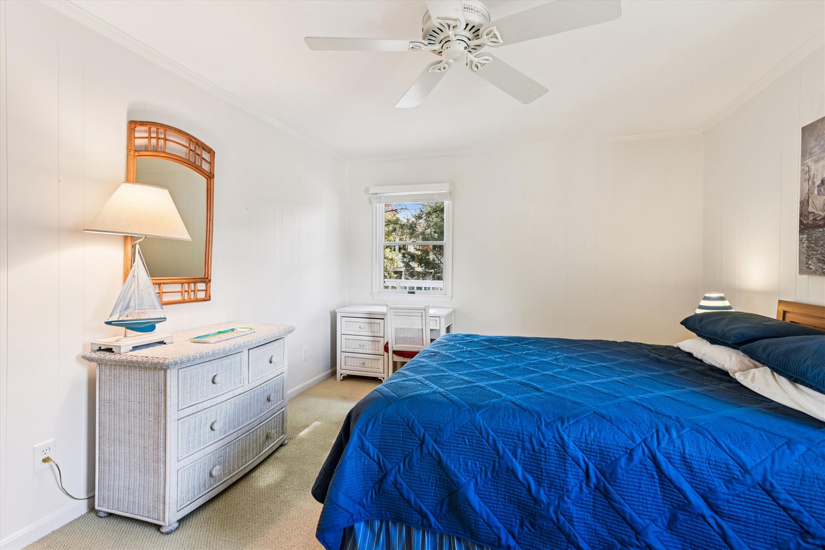 Drift off in your peaceful bedroom with coastal charm, soft linens, and gentle breezes from the ceiling fan.