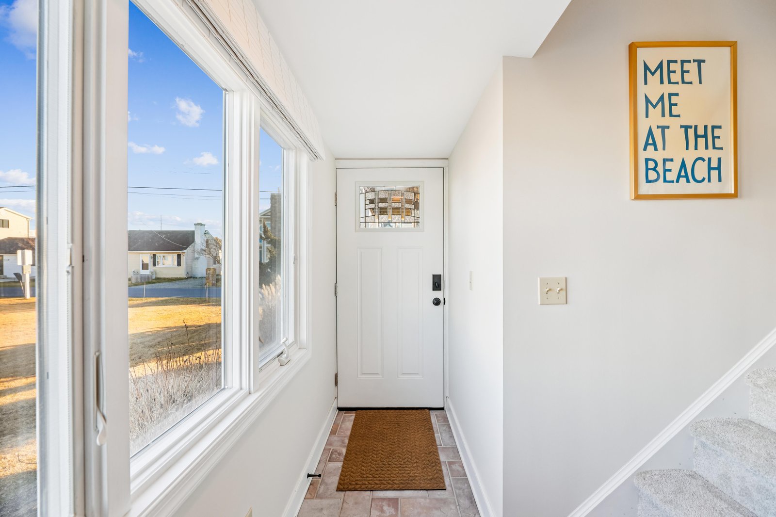 Step into your bright, welcoming entryway with cheerful beach vibes and abundant natural light. Your coastal getaway begins right here, just moments from sandy shores.