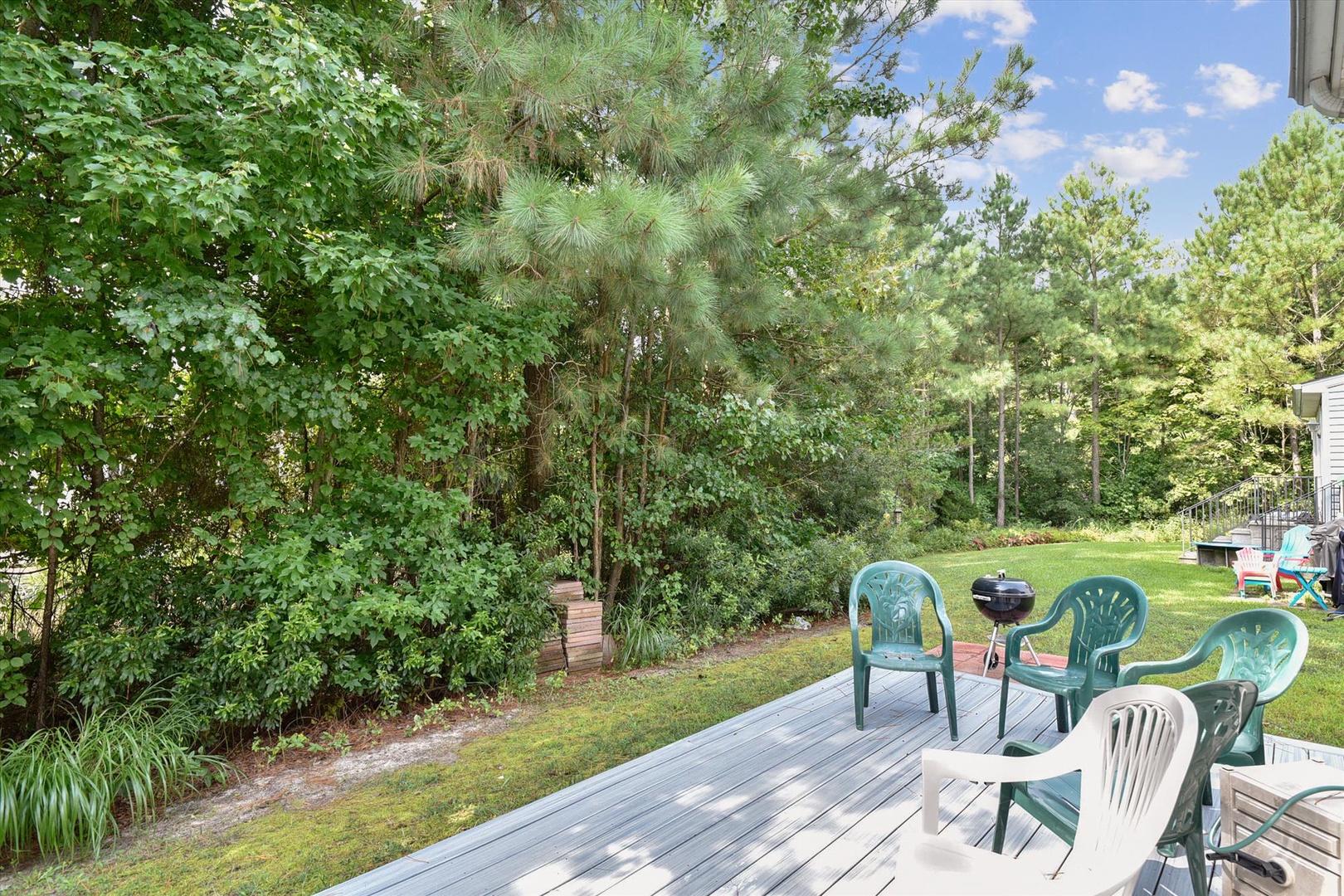 Unwind on your private deck surrounded by towering pines and open lawn, perfect for morning coffee or evening BBQs under the open sky.