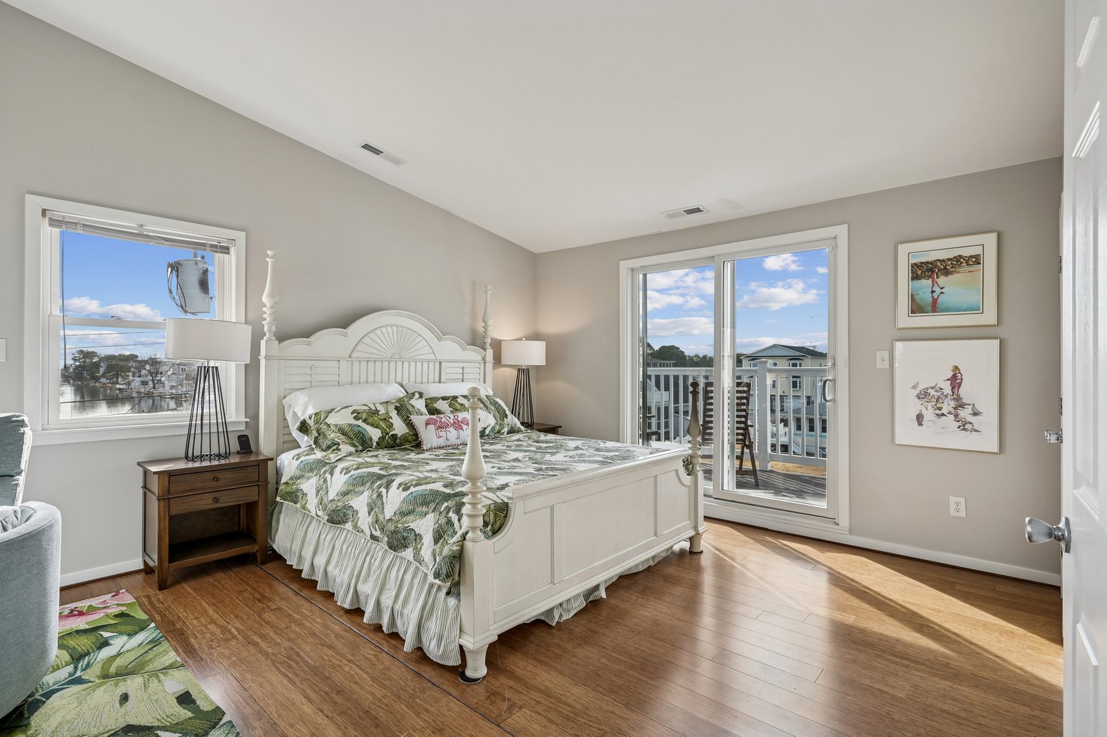 Drift off in this airy bedroom with tropical bedding, gleaming hardwood floors, and French doors opening to your private balcony.
