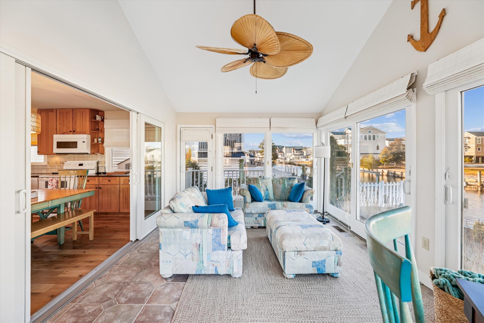 Relax in your bright coastal living room with panoramic water views, where ocean breezes flow through floor-to-ceiling windows.