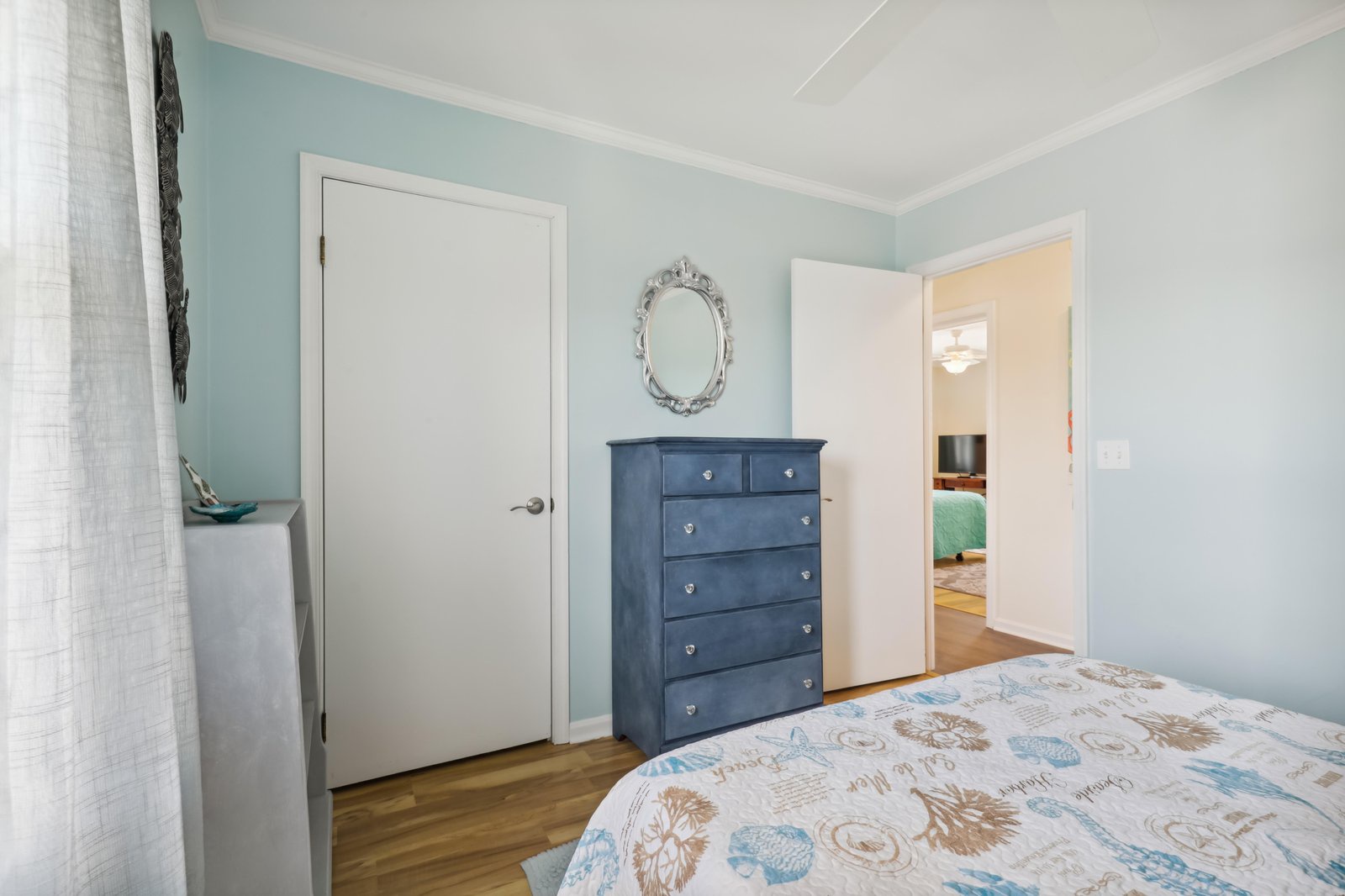 Drift off in this tranquil bedroom where soft coastal hues and warm wood floors welcome your well-deserved rest, with all your belongings tucked neatly away.