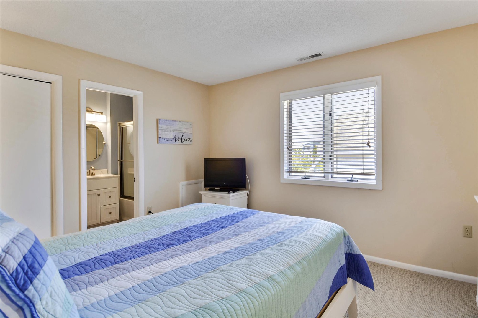 Unwind in your serene bedroom, where natural light spills through bright windows and coastal blues invite restful sleep. Your private ensuite awaits just steps away.