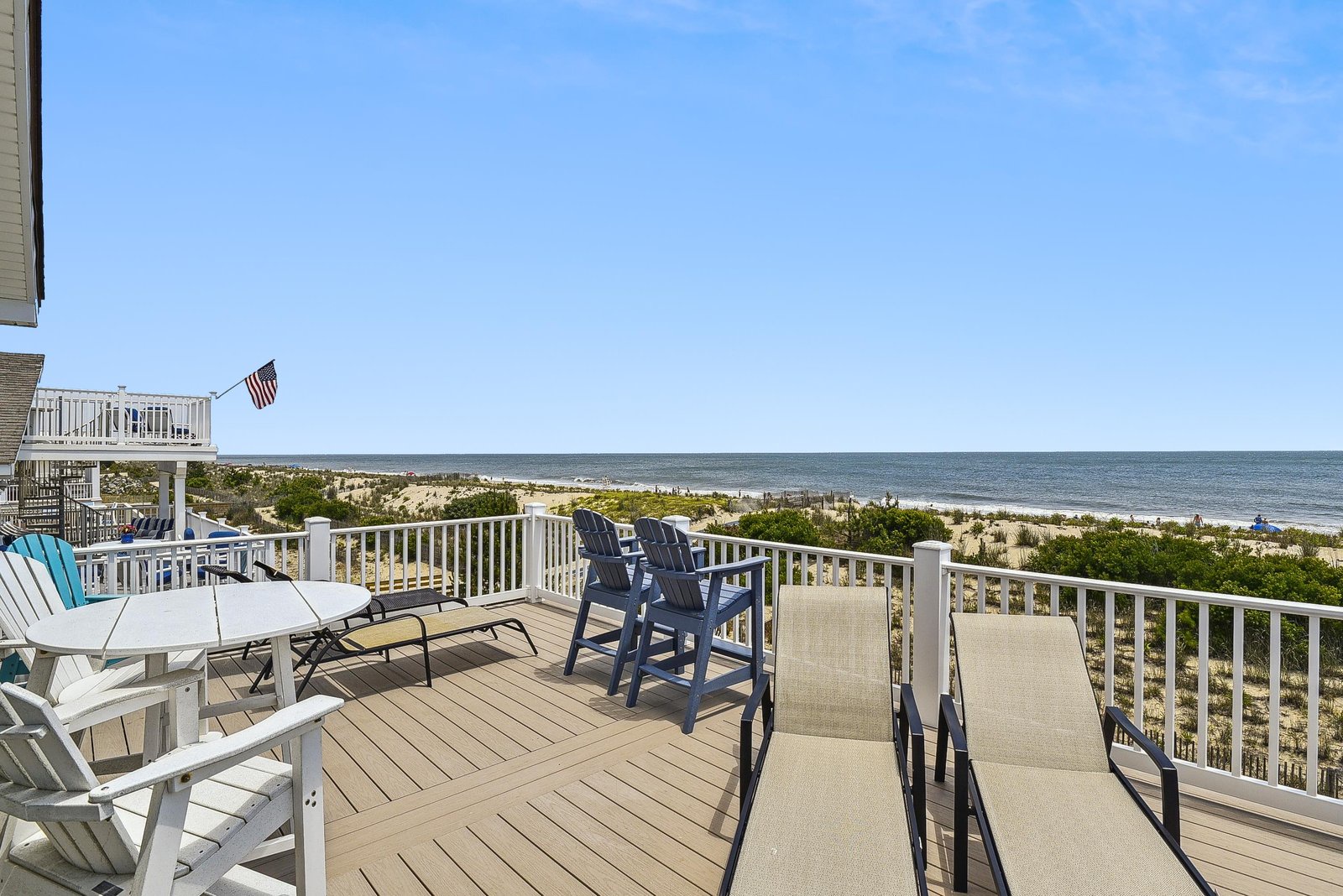 Expansive oceanfront deck with sweeping views of sandy beaches and rolling waves. The spacious outdoor area features casual seating where you can soak in the coastal breeze.