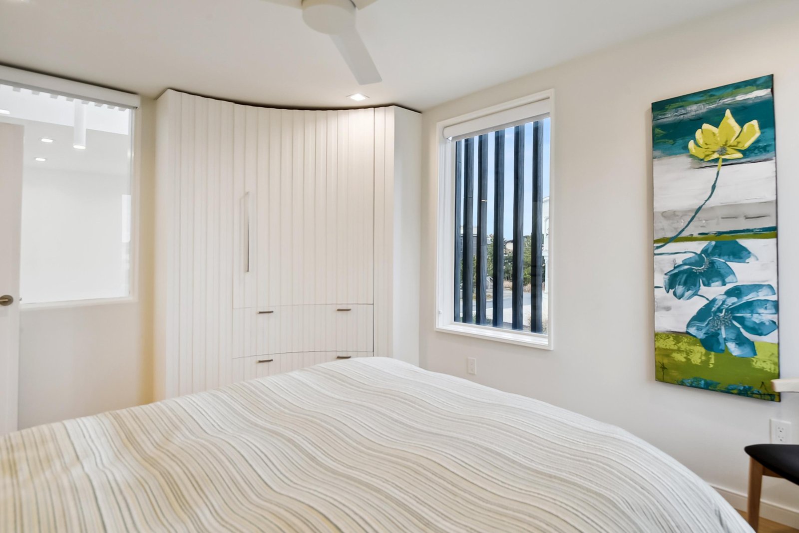 Sink into crisp linens in this serene bedroom, where ample built-in storage and a gentle breeze from the ceiling fan help you unwind after a day of exploring.