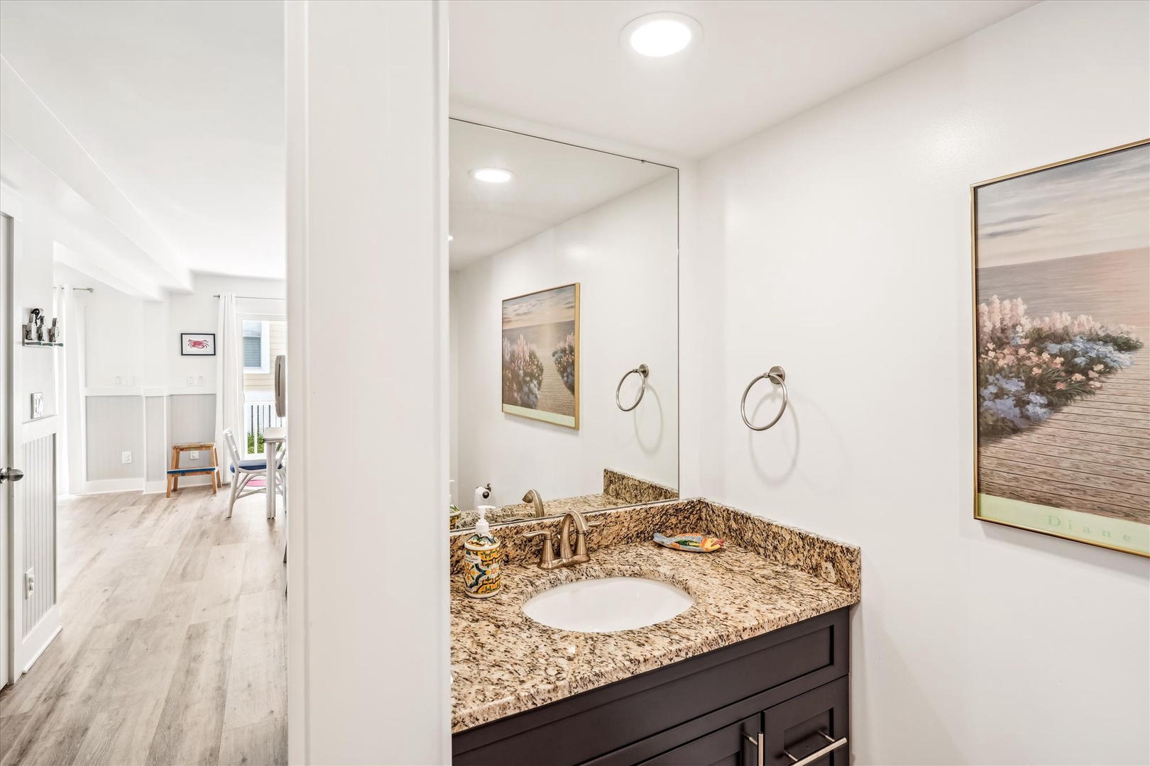 Your private vanity area features beautiful granite countertops and peaceful artwork, creating a serene space for your morning routine.