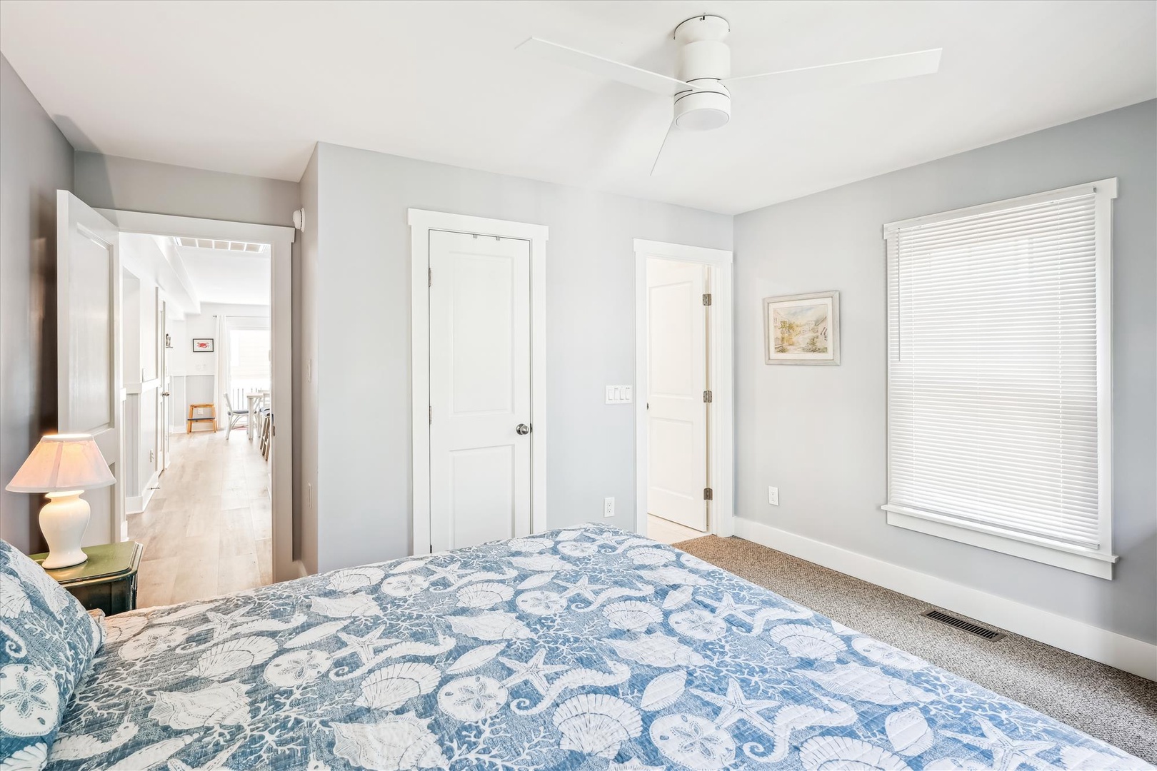 Drift off in this peaceful bedroom featuring soft blue linens, natural light, and coastal charm.