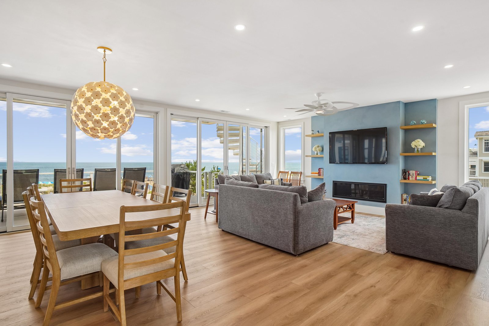Picture yourself relaxing in this bright, open living space with stunning ocean views through floor-to-ceiling windows. The cozy seating area invites you to unwind while enjoying the coastal scenery that frames your getaway.