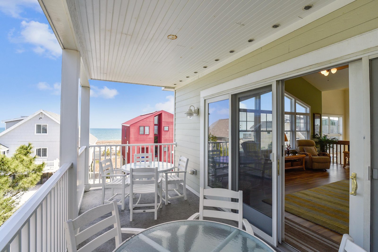 Step out onto your private balcony and feel the ocean breeze as you take in stunning views of the sea and nearby colorful beach cottages. Perfect for morning coffee or sunset conversations.