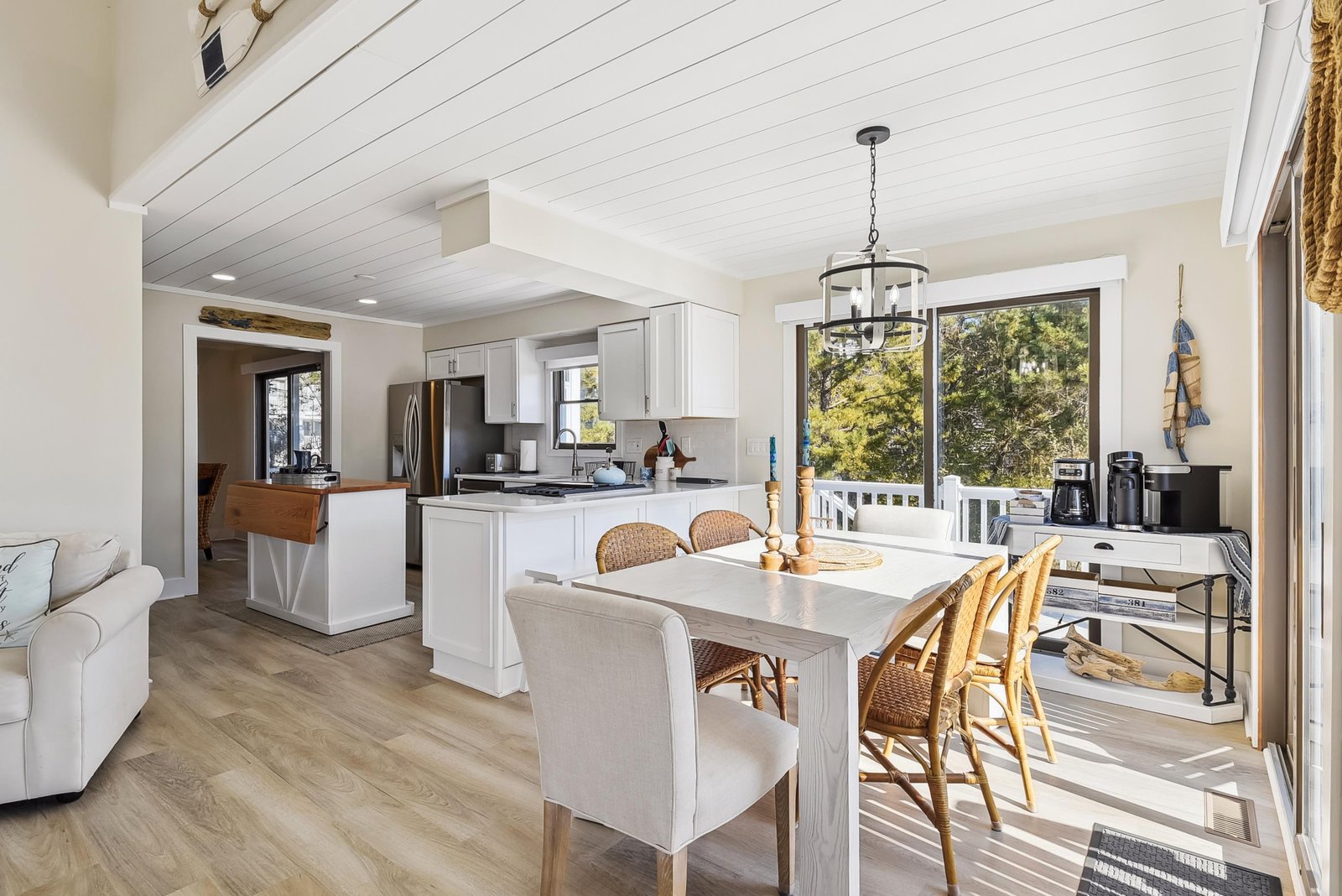 Sunlit living and kitchen flow into a bright dining area where natural light and coastal charm invite relaxed mornings and effortless entertaining.