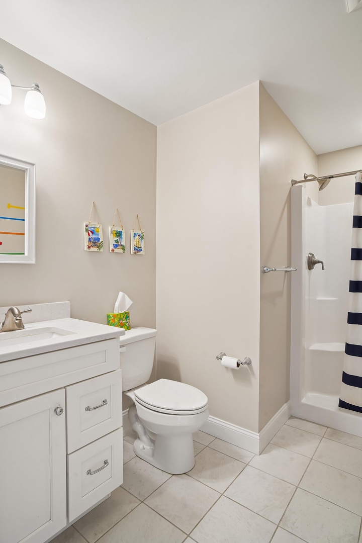Your bathroom is bright and spotless, with a roomy shower, fresh towels, and cheerful beach-themed art to set the tone for your getaway.
