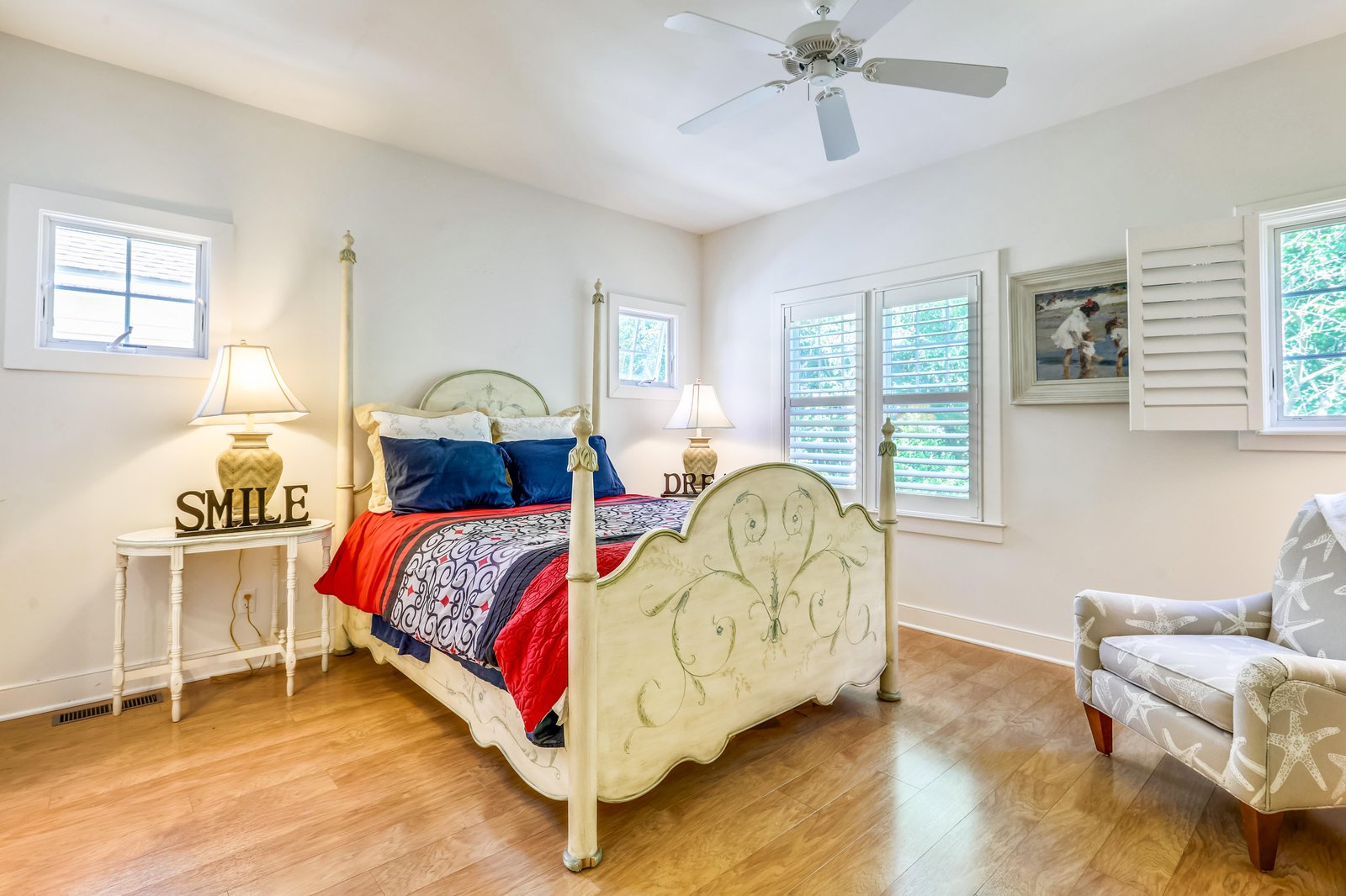 Sink into your charming four-poster bed, surrounded by soft natural light filtering through plantation shutters. Hardwood floors and a cozy seating nook await your morning coffee.