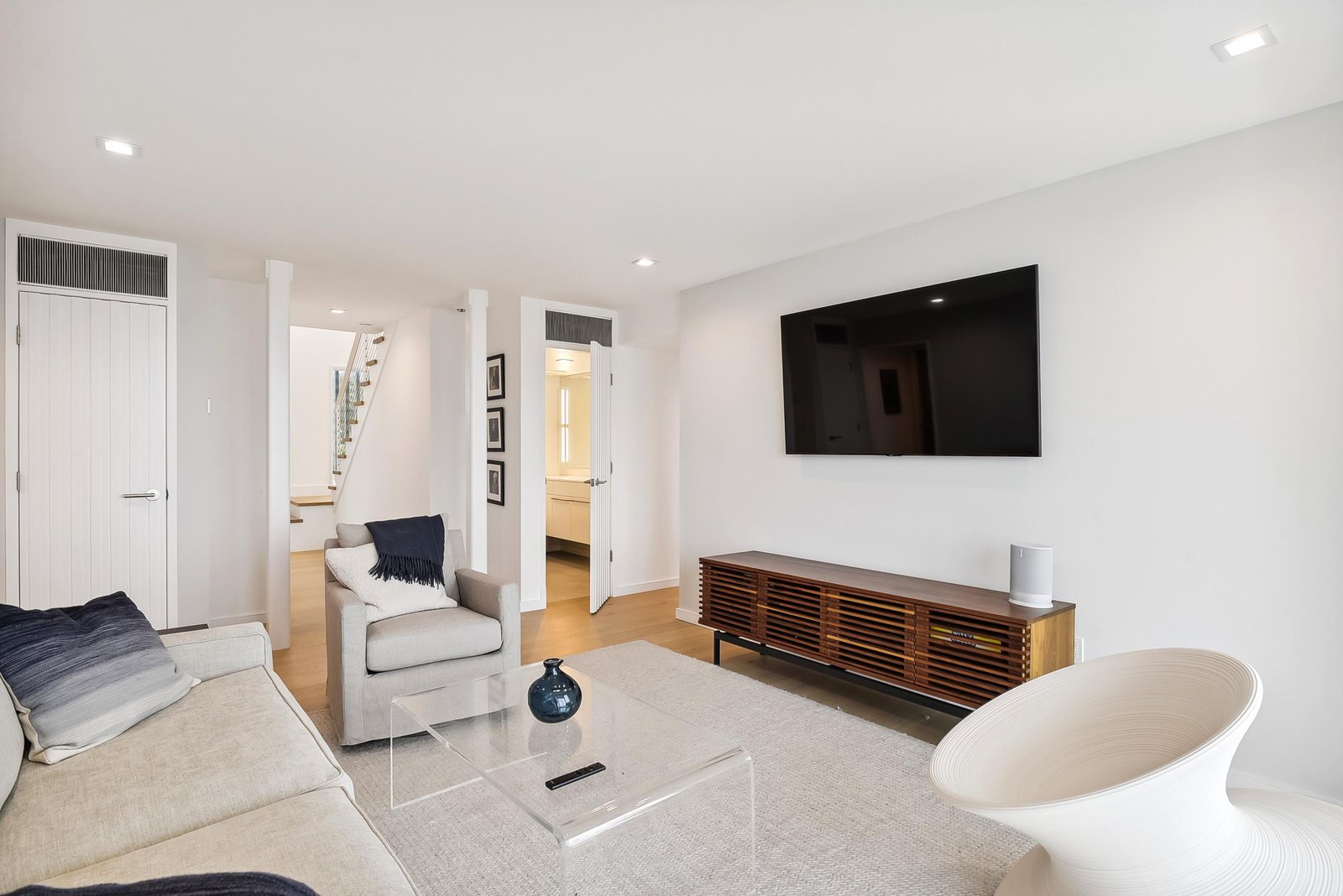 Settle into this bright, modern living room where clean lines and minimalist style create the perfect backdrop for your relaxation. Sink into the plush seating and enjoy your favorite shows on the large TV after a day of exploring.