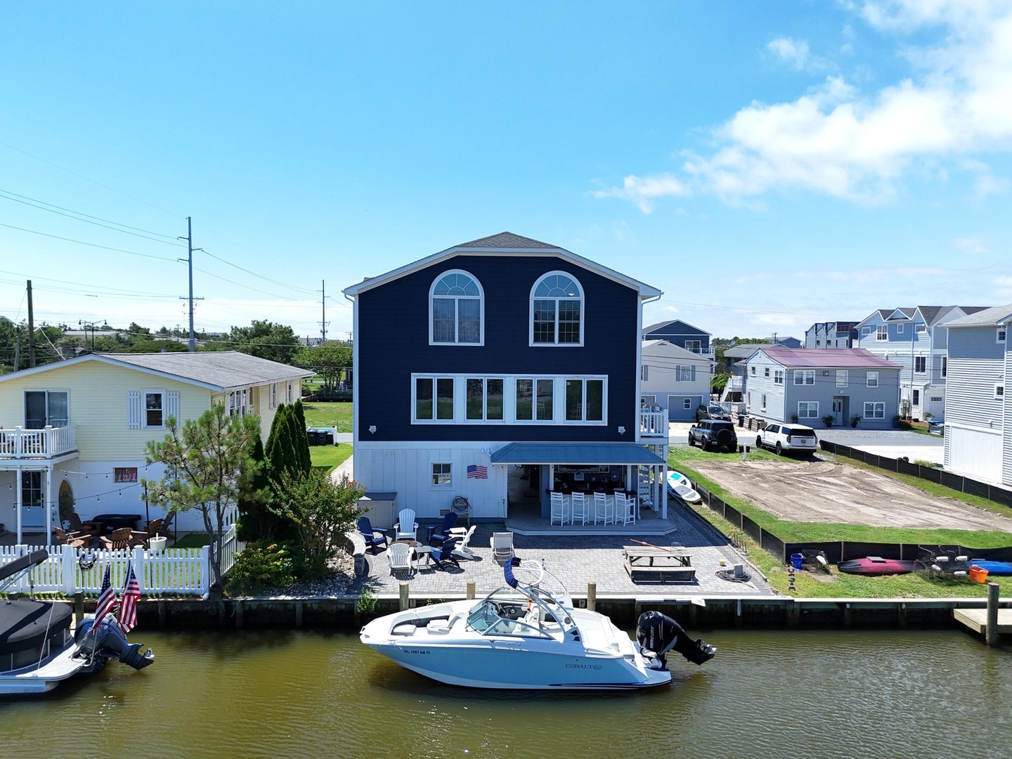 Navy-blue waterfront property with private dock and boat access set in a quiet residential canal neighborhood.