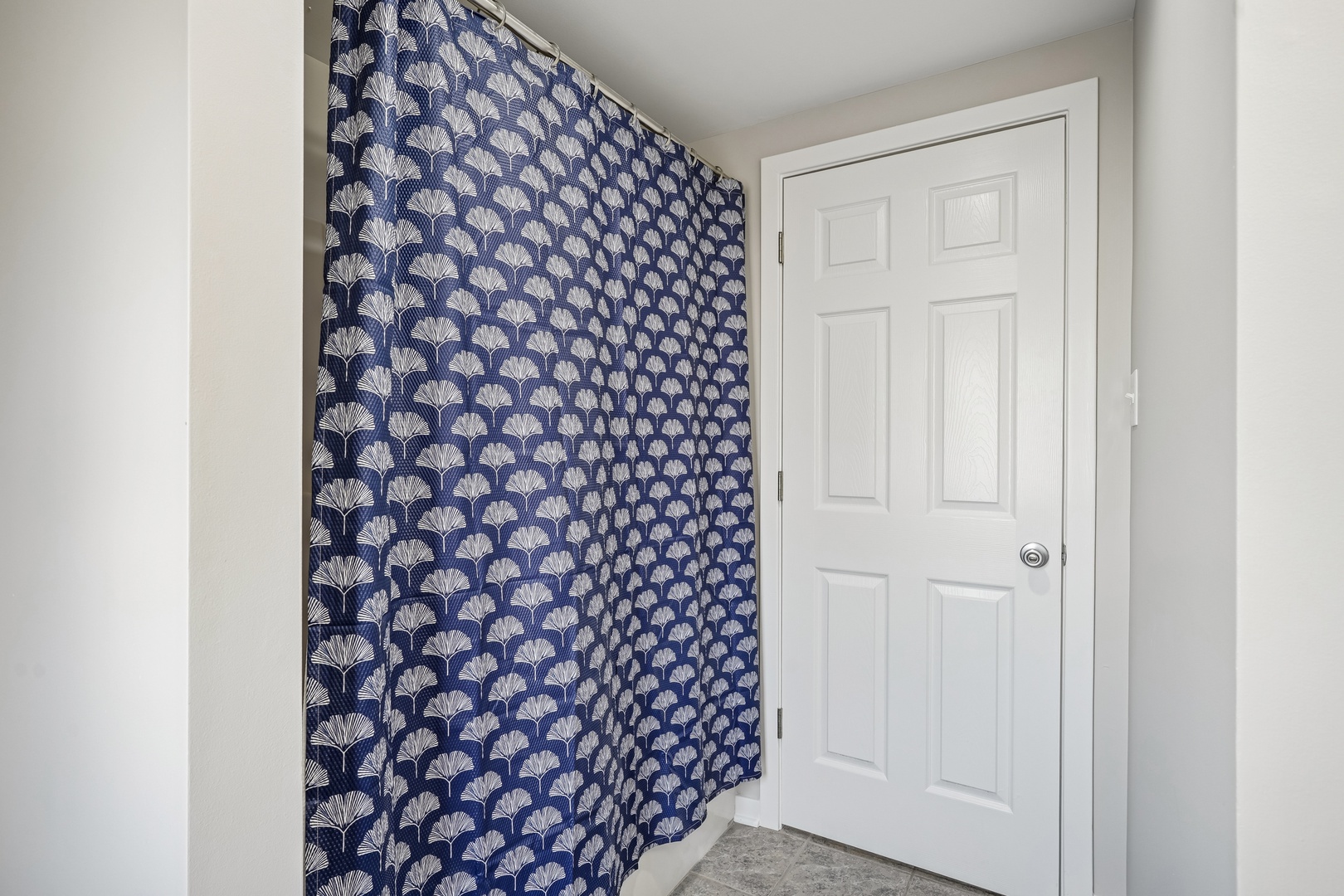 Step into your stylish entryway featuring elegant navy wallpaper with intricate shell patterns and crisp white details.