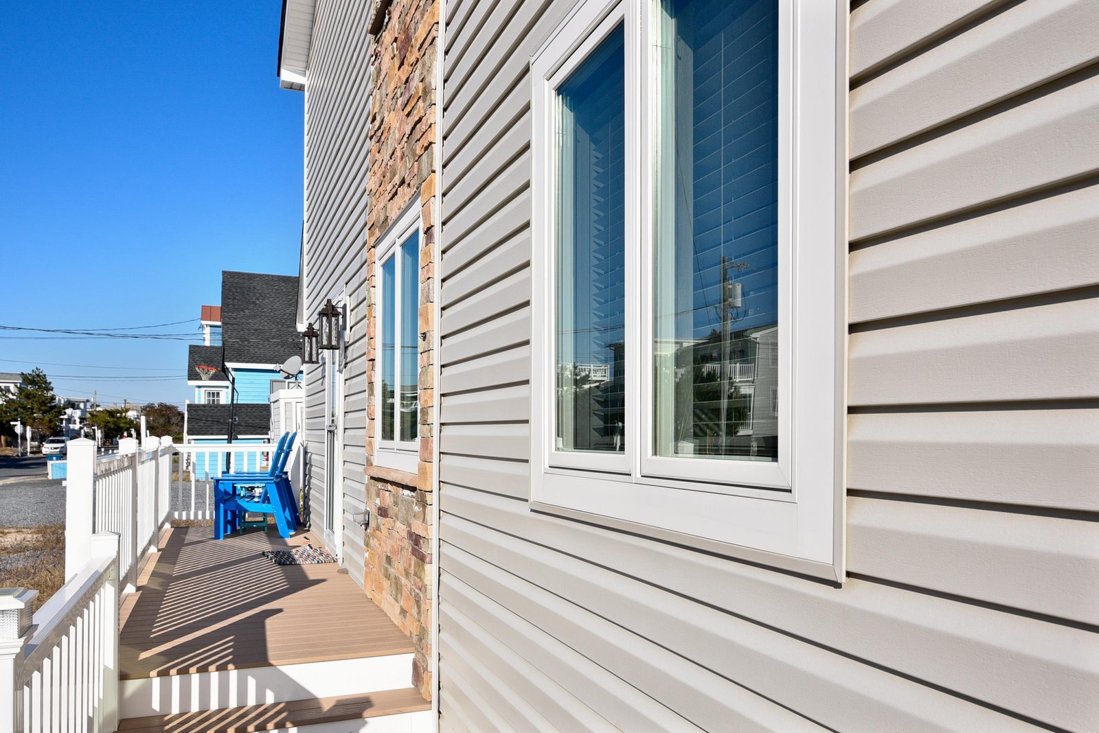 Charming coastal property with white siding and brick accents. The rental sits in a quiet neighborhood with easy street access, just steps from your beach getaway.