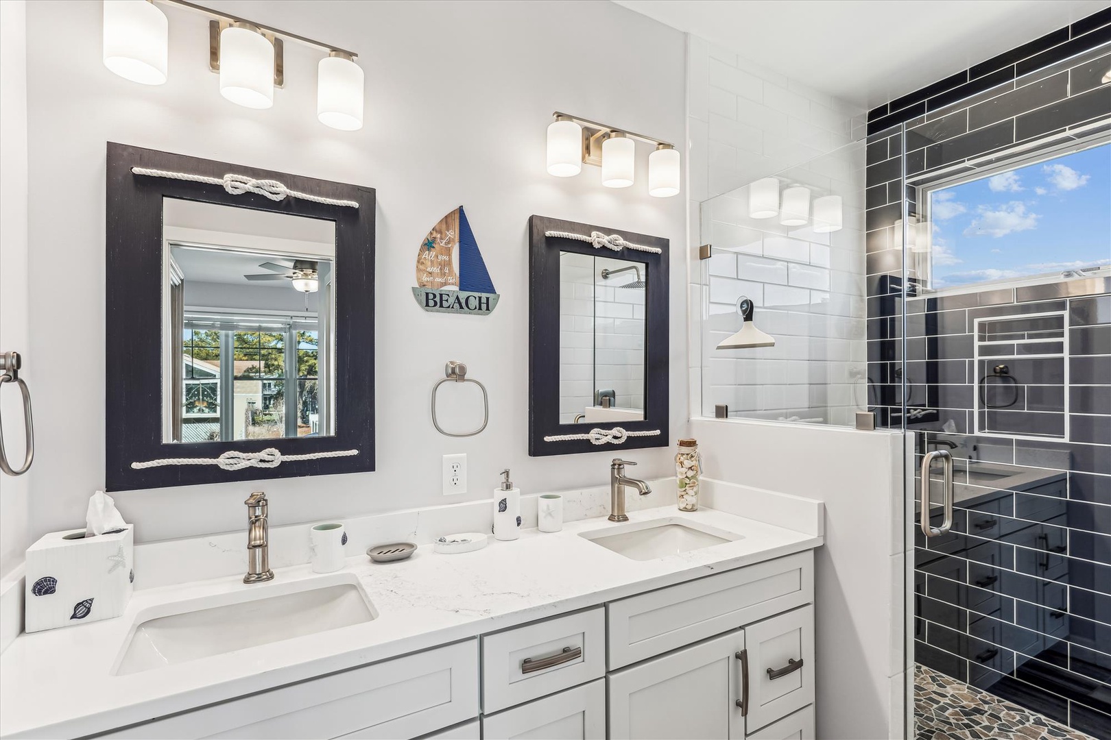 Unwind in your beautifully appointed bathroom with dual vanities, nautical charm, and a stunning tiled shower perfect for refreshing after beach days.