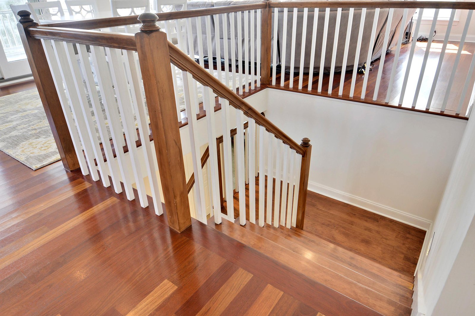 Polished hardwood stairs connect the levels of this inviting property, blending warm wood tones with clean white railings for a bright, welcoming feel.