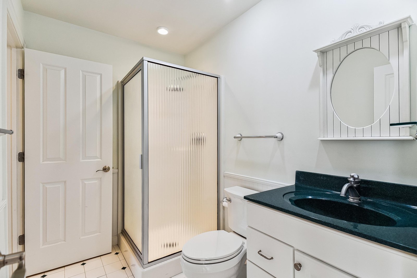 Freshen up in your private bathroom with a roomy walk-in shower, a deep teal countertop, and plenty of storage for your essentials.
