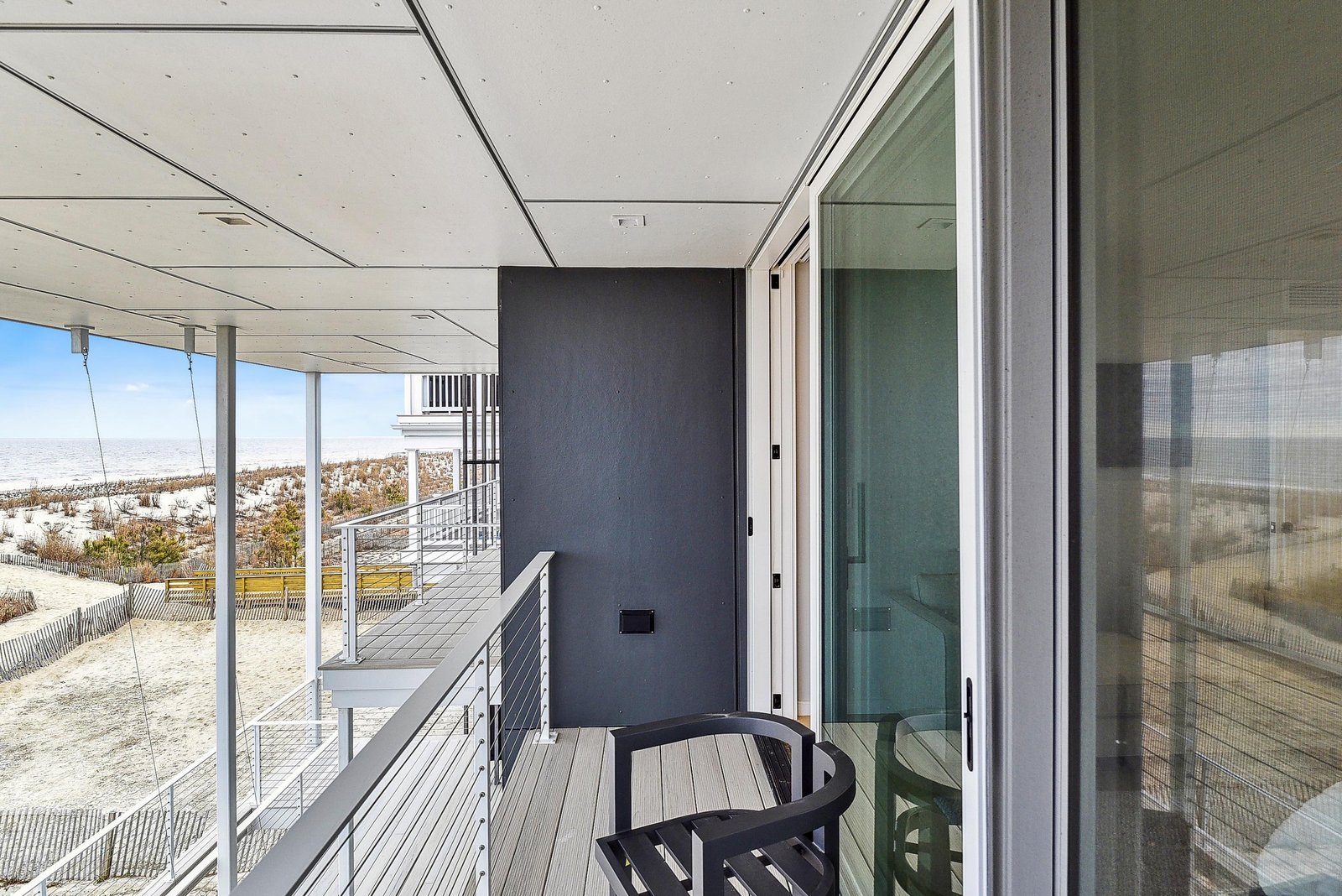 Step outside onto your private deck, where dune-scattered ocean views stretch before you under expansive coastal skies—a tranquil spot for morning coffee or evening relaxation.