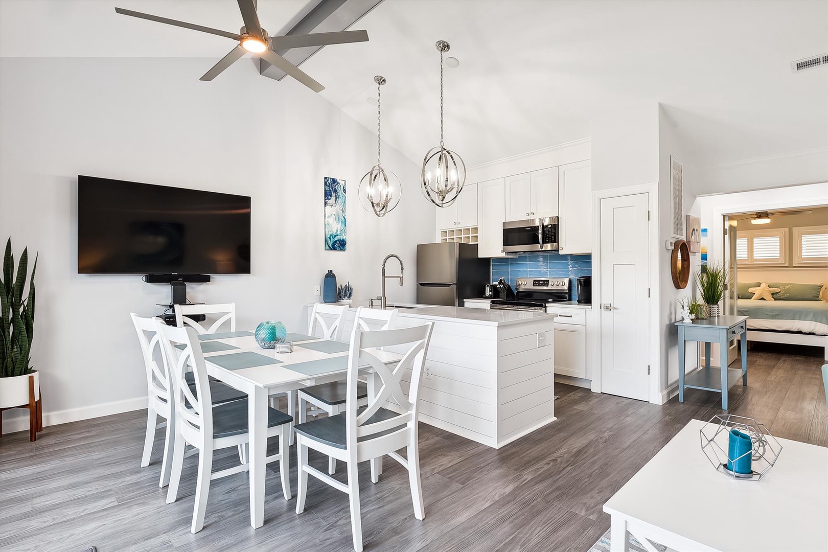 Your open-concept retreat blends living, dining, and kitchen in a bright, airy space. White finishes and pops of coastal blue invite you to relax and gather.
