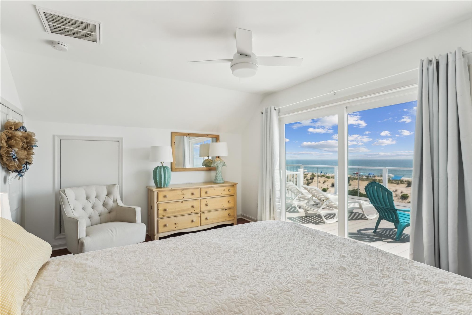 Wake up to sparkling ocean views and gentle breezes in this serene coastal bedroom. Sliding doors open to a private balcony with poolside seating—your perfect morning retreat.