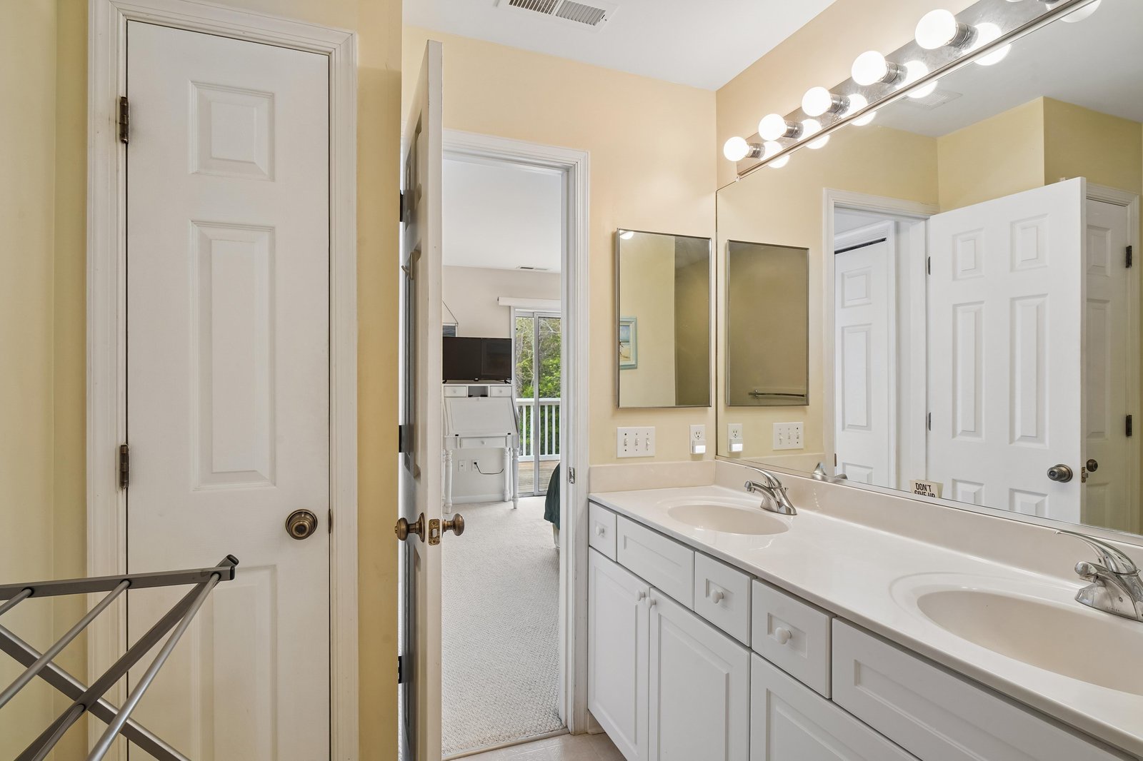 Your private bathroom features dual sinks with plenty of counter space, bright vanity lighting for your morning routine, and a bright, welcoming layout with thoughtful storage.
