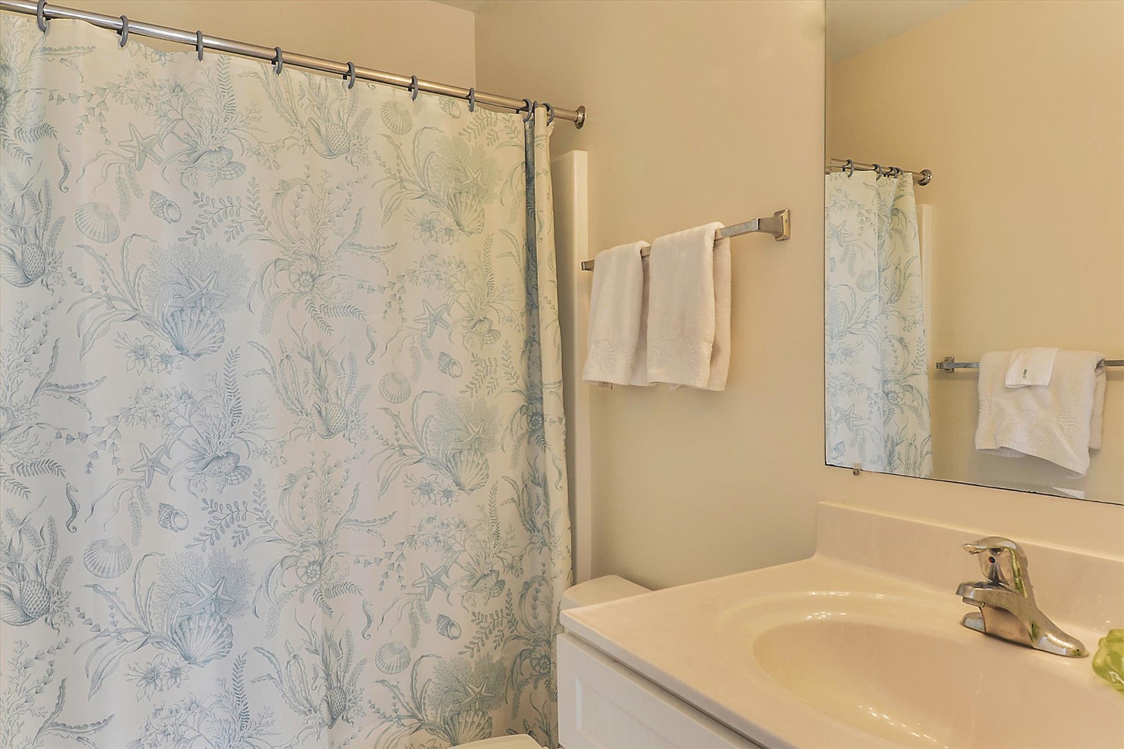 Step into your private bathroom featuring a full shower-tub combo, plush towels, and a sparkling clean vanity ready for your morning routine.