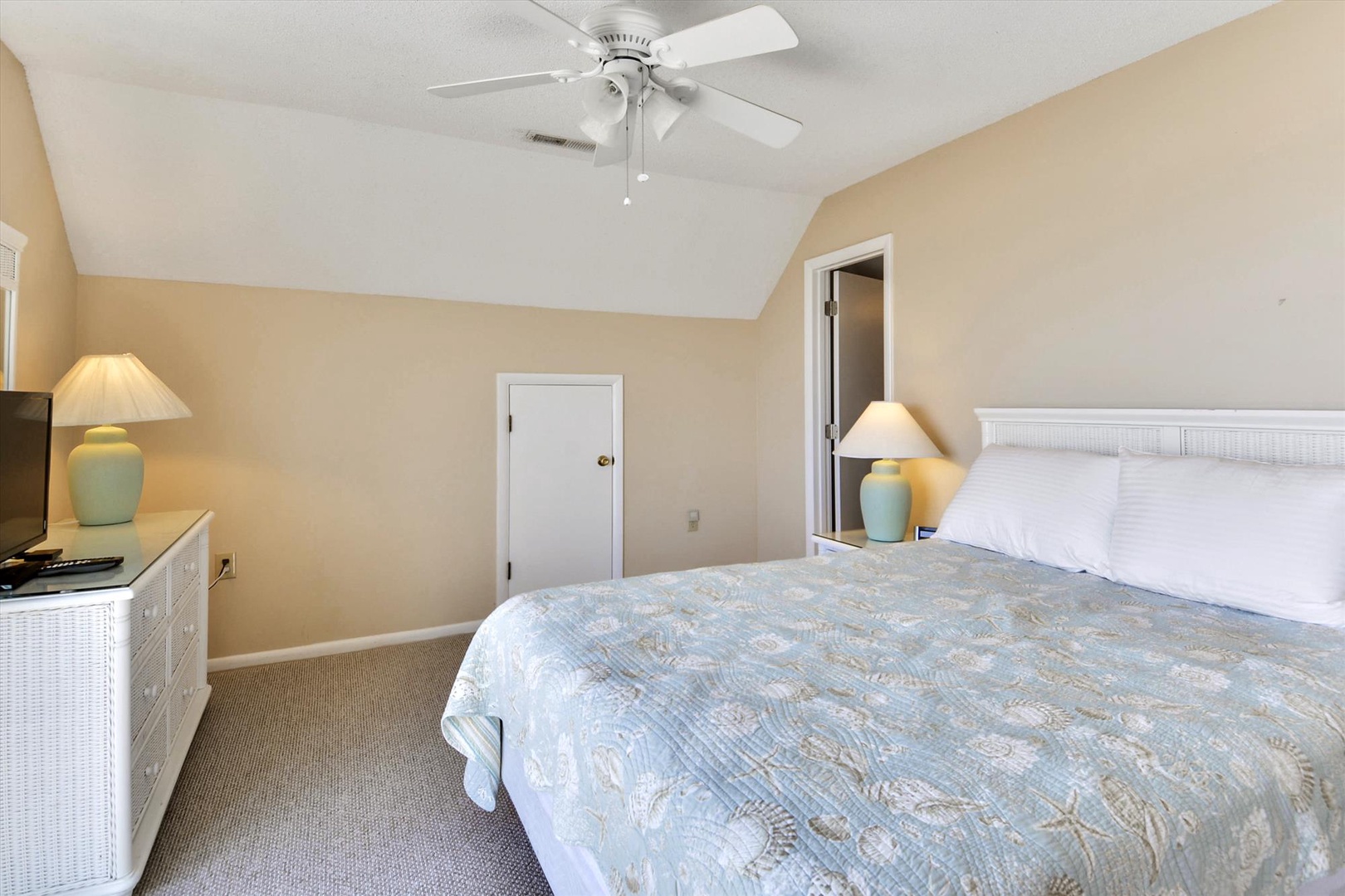Relax in your bright bedroom with vaulted ceilings, soft coastal linens, and calming touches—your personal retreat after sun-soaked days awaits.