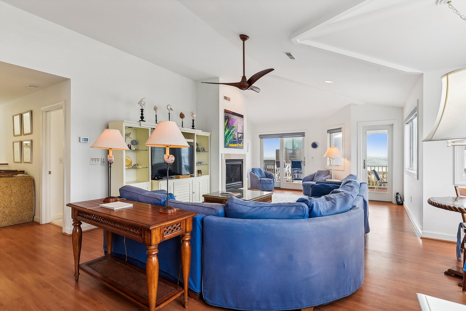 Settle into plush seating as natural light pours through expansive glass doors, revealing sweeping ocean views and inviting you to your personal coastal retreat.