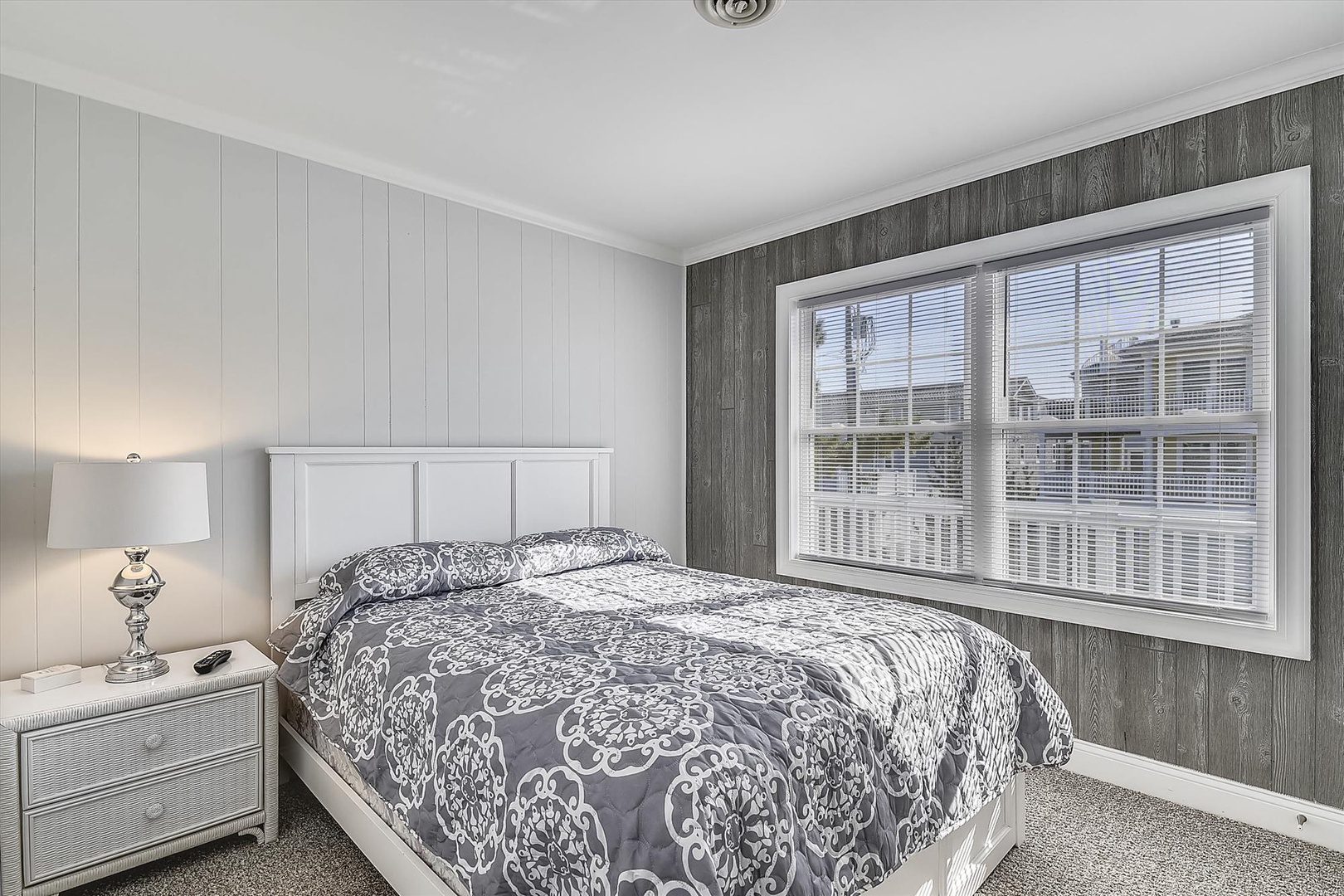 Step into your serene bedroom retreat with crisp white furnishings, coastal-inspired wood paneling, and soft morning light filtering through the windows—your perfect haven for unwinding after a day at the beach.