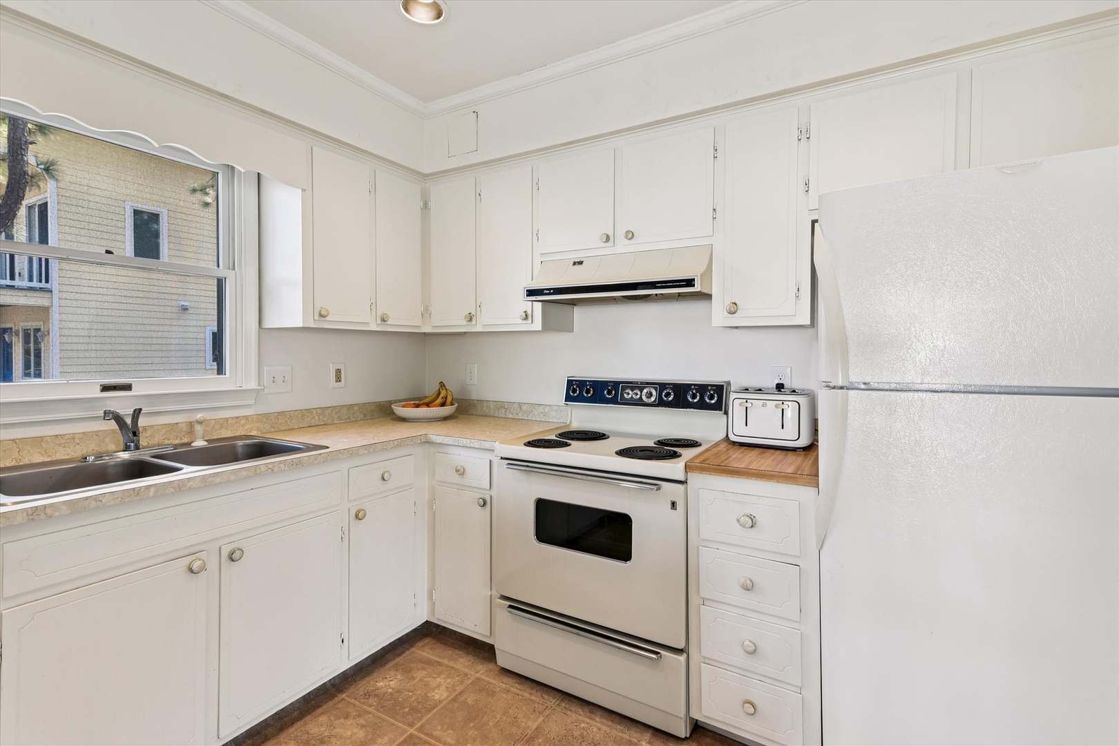 Your fully equipped kitchen features everything needed for home cooking, from spacious white cabinets to modern appliances and plenty of counter space.