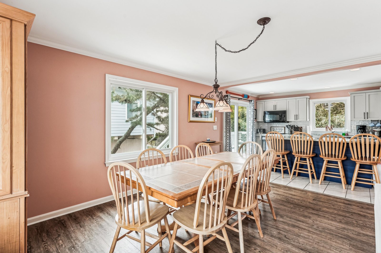 Gather around warm wood tones and abundant natural light in your spacious dining area, where ample seating invites memorable meals and lively conversation with loved ones.