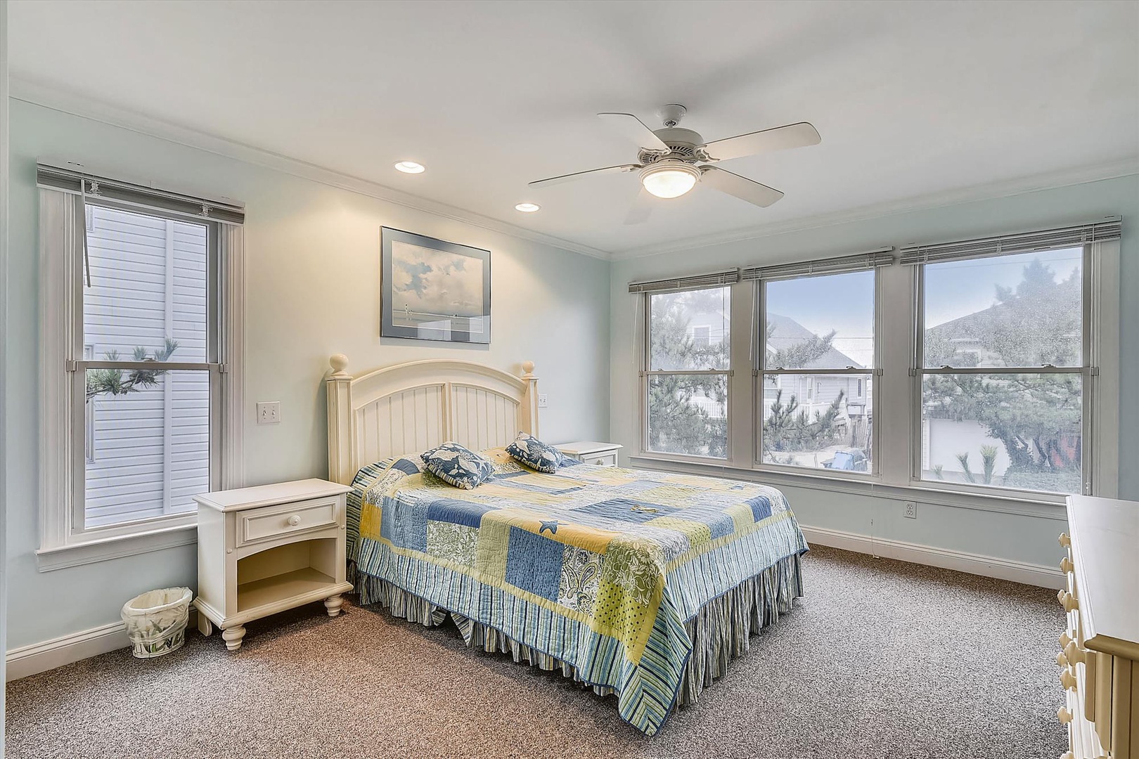 Wake up refreshed in your coastal-inspired bedroom, where soft natural light pours through large windows, and a gentle ceiling fan keeps you comfortable all season long.