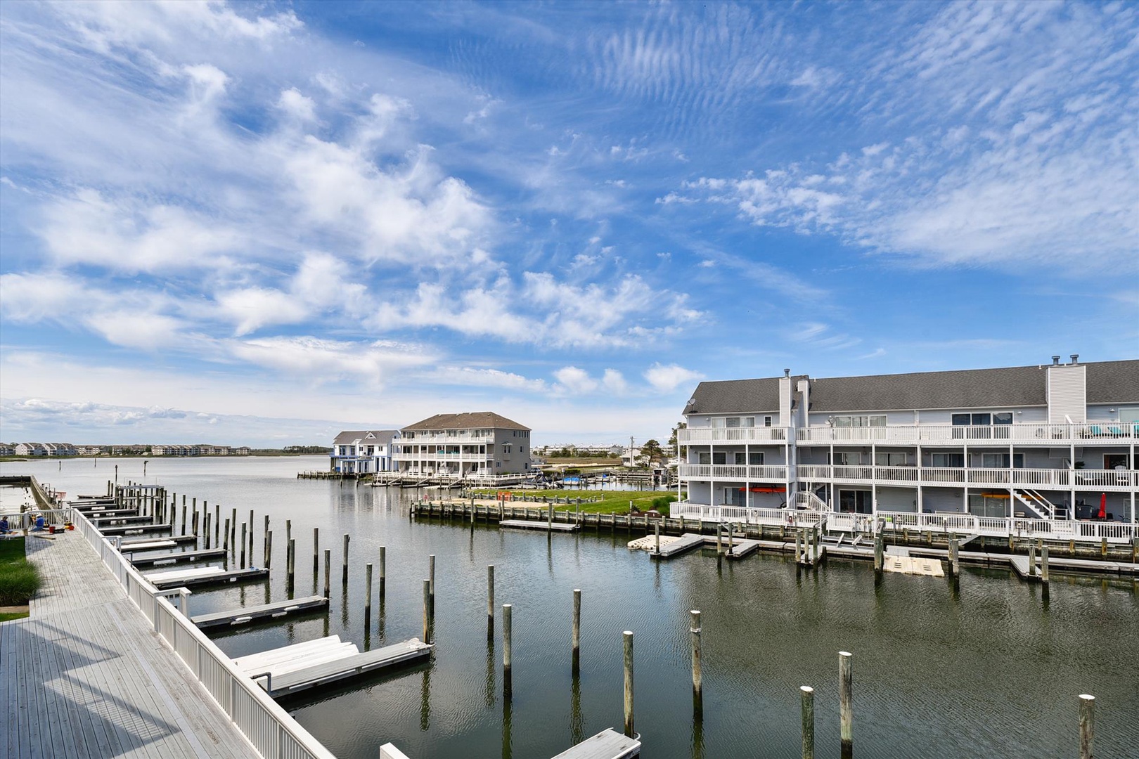 A serene waterfront community with private boat docks, surrounded by peaceful waters and open skies—part of the property's charming coastal setting.