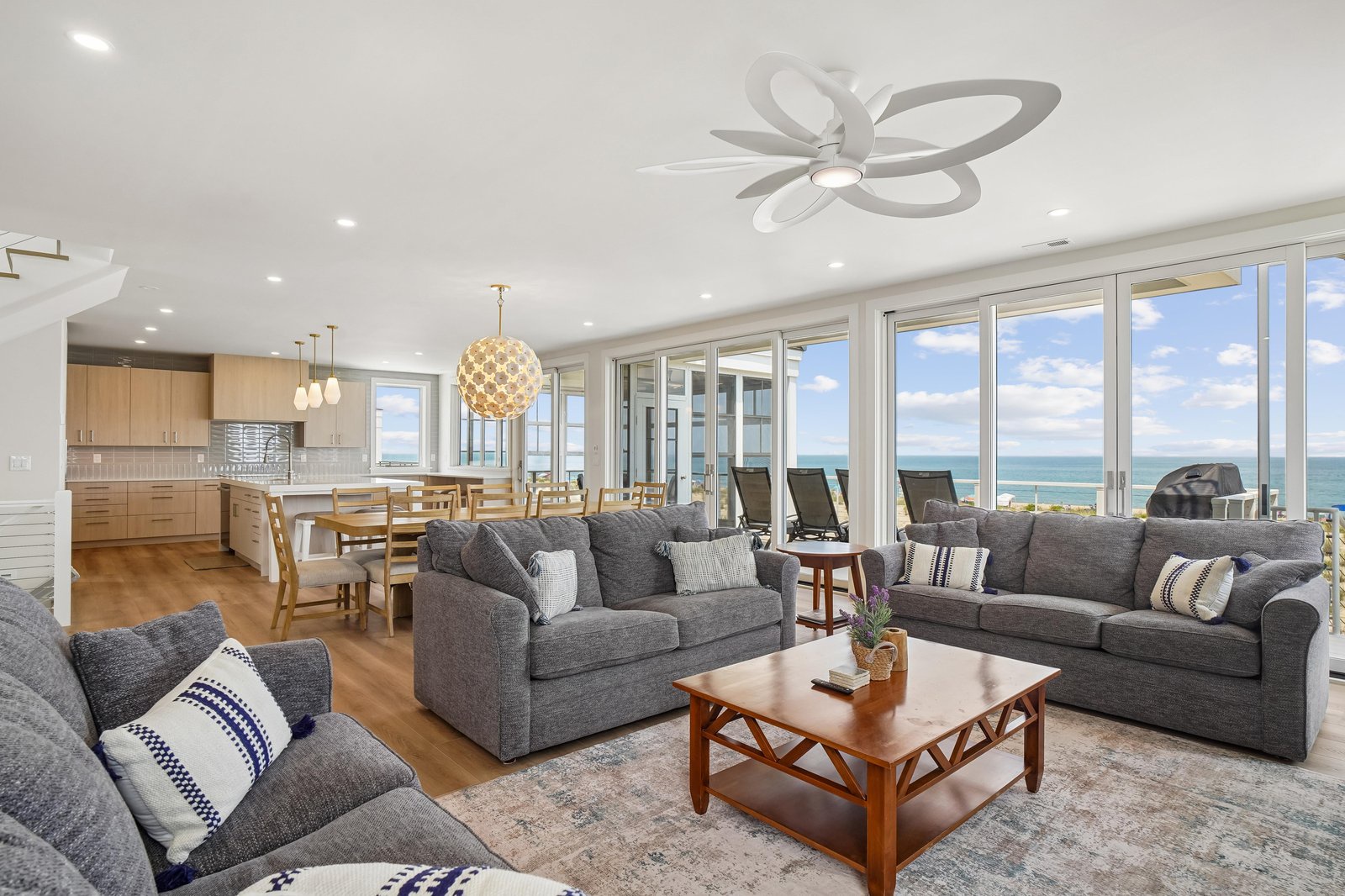 Relax in your open-concept living space where floor-to-ceiling windows frame sweeping ocean views, inviting you to unwind on plush sofas as natural light fills every corner.