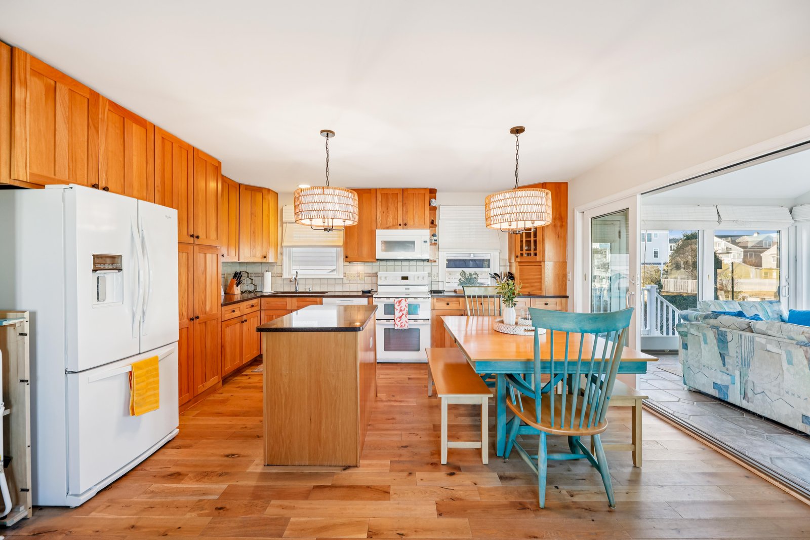 Step into a bright, coastal-inspired kitchen with warm wood cabinetry and charming turquoise accents. Your open layout flows effortlessly into the living space, perfect for gathering with loved ones.